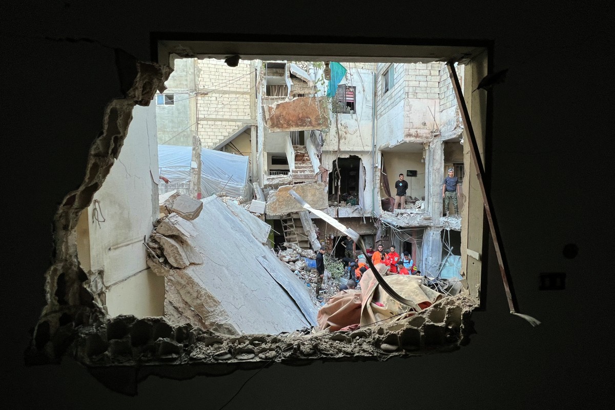 Residents and rescue teams inspect the damage following an overnight Israeli air strike on the Ain el-Helweh camp for Palestinian refugees on the outskirts of the southern port city of Sidon