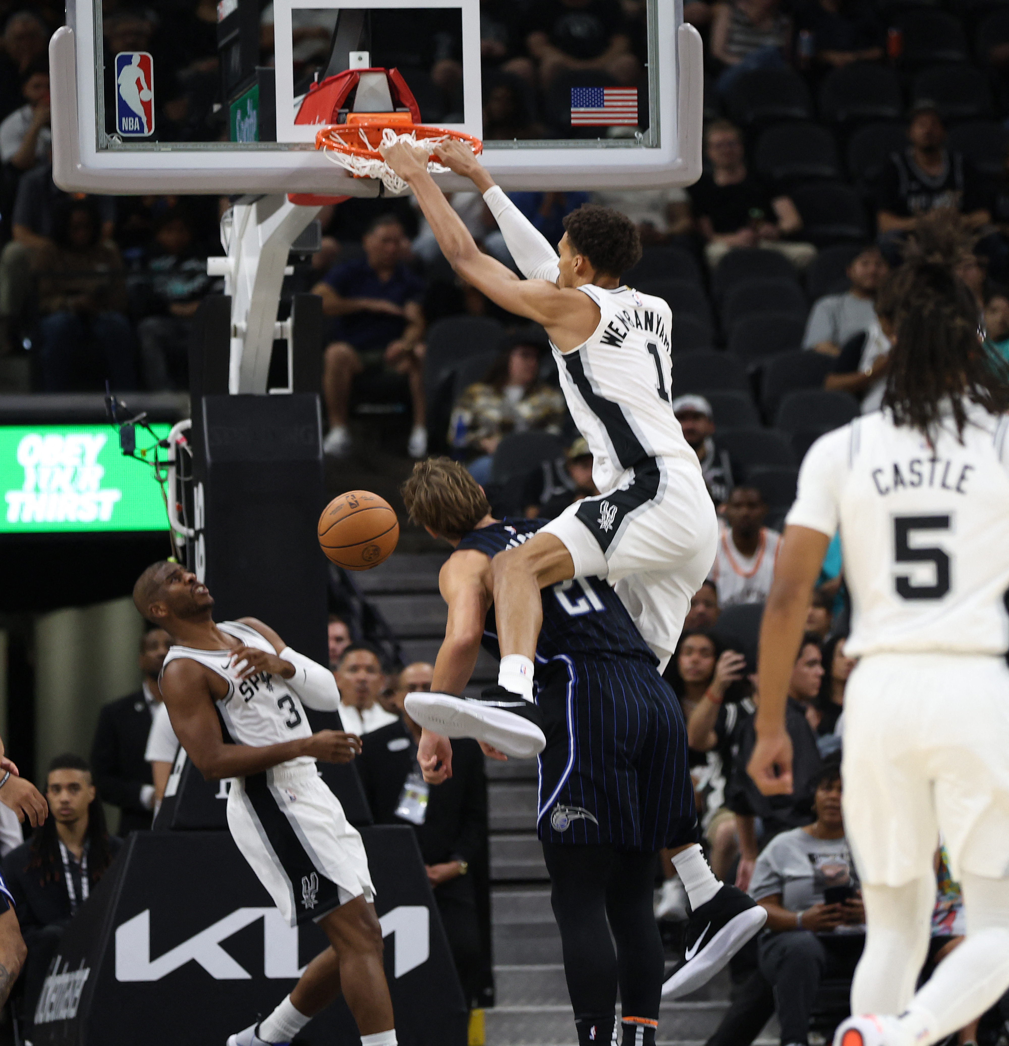 Victor Wembanyama #1 of the San Antonio Spurs dunks over Moritz Wagner #21 of the Orlando Magic in a preseason game on October 9, 2024 in San Antonio, Texas