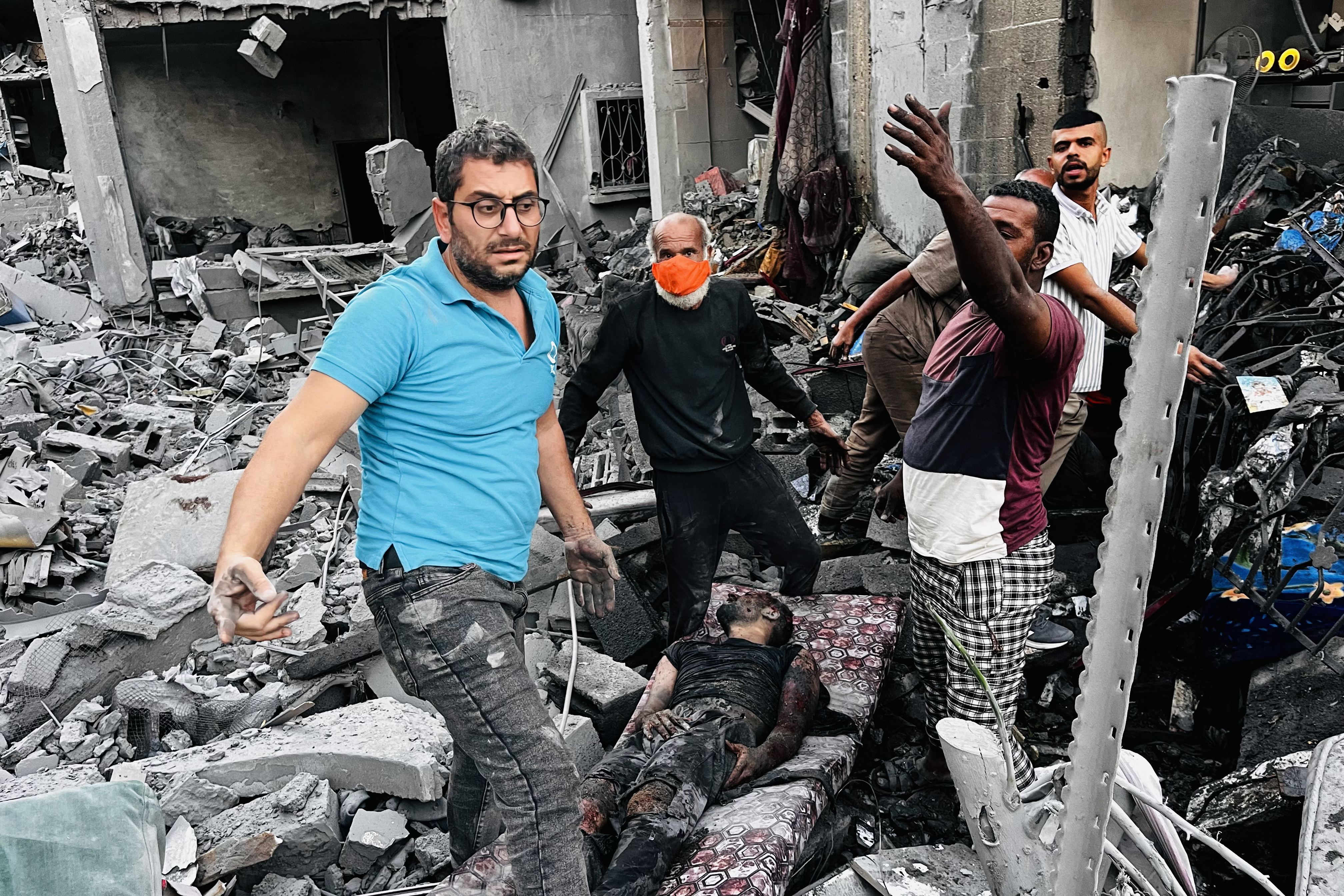 Palestinians help a wounded man at the site of an Israeli strike in Jabalia in the northern Gaza Strip