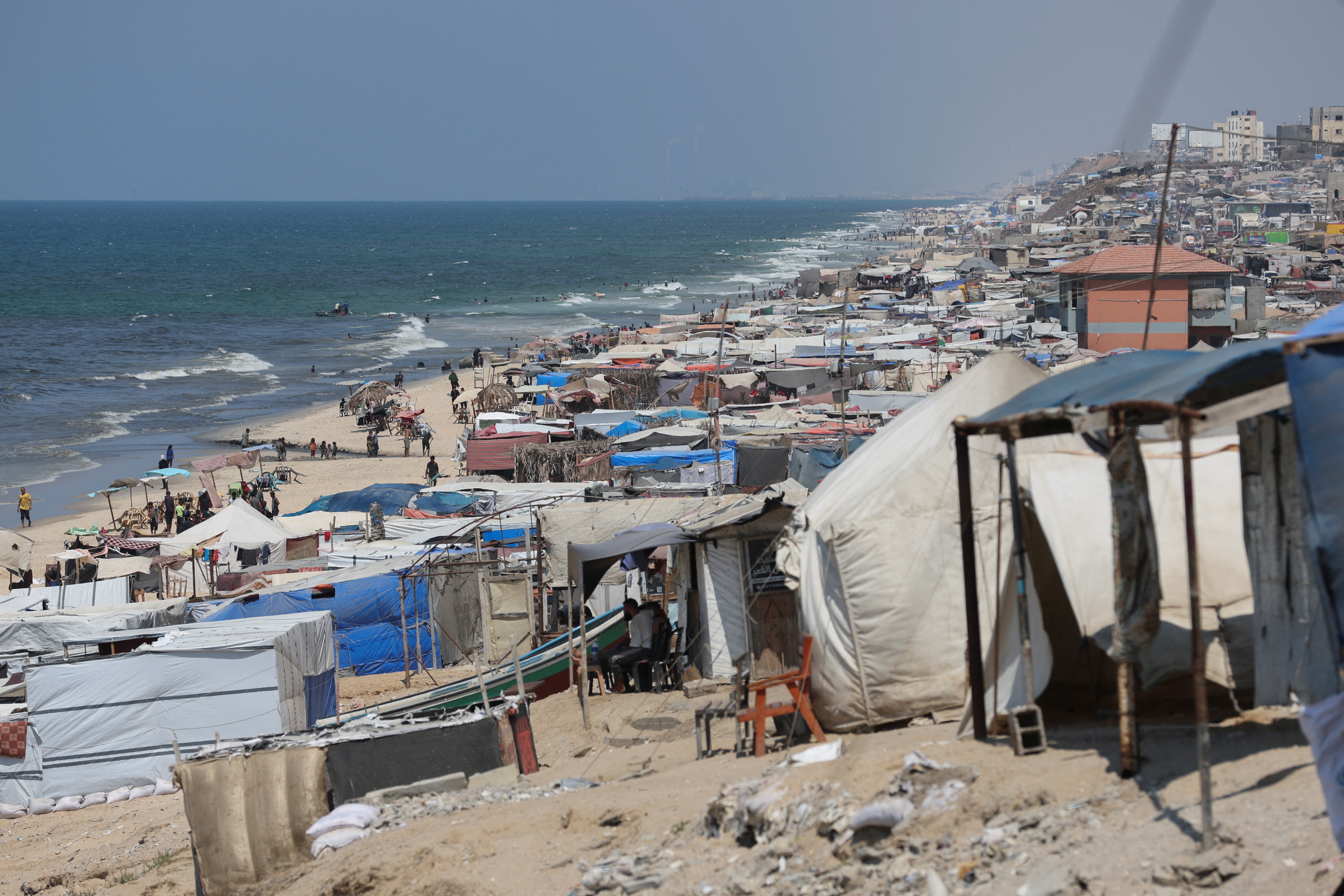 Displaced Palestinians shelter on a beach, amid Israel-Hamas conflict, in Deir Al-Balah in the central Gaza Strip, August 27, 2024. REUTERS/Ramadan Abed