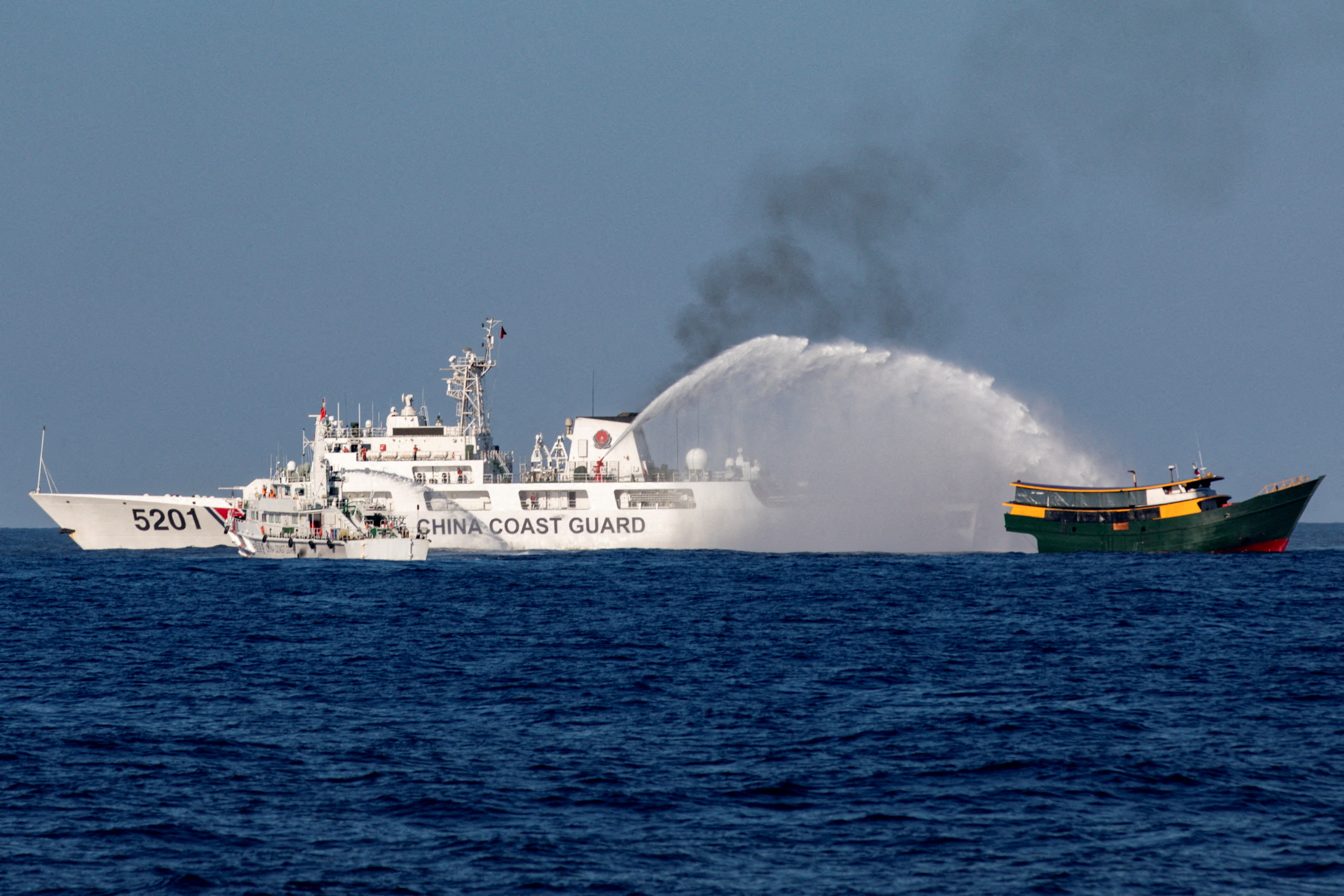 Chinese Coast Guard ships use water cannon on a Philippine resupply vessel in the South China Sea