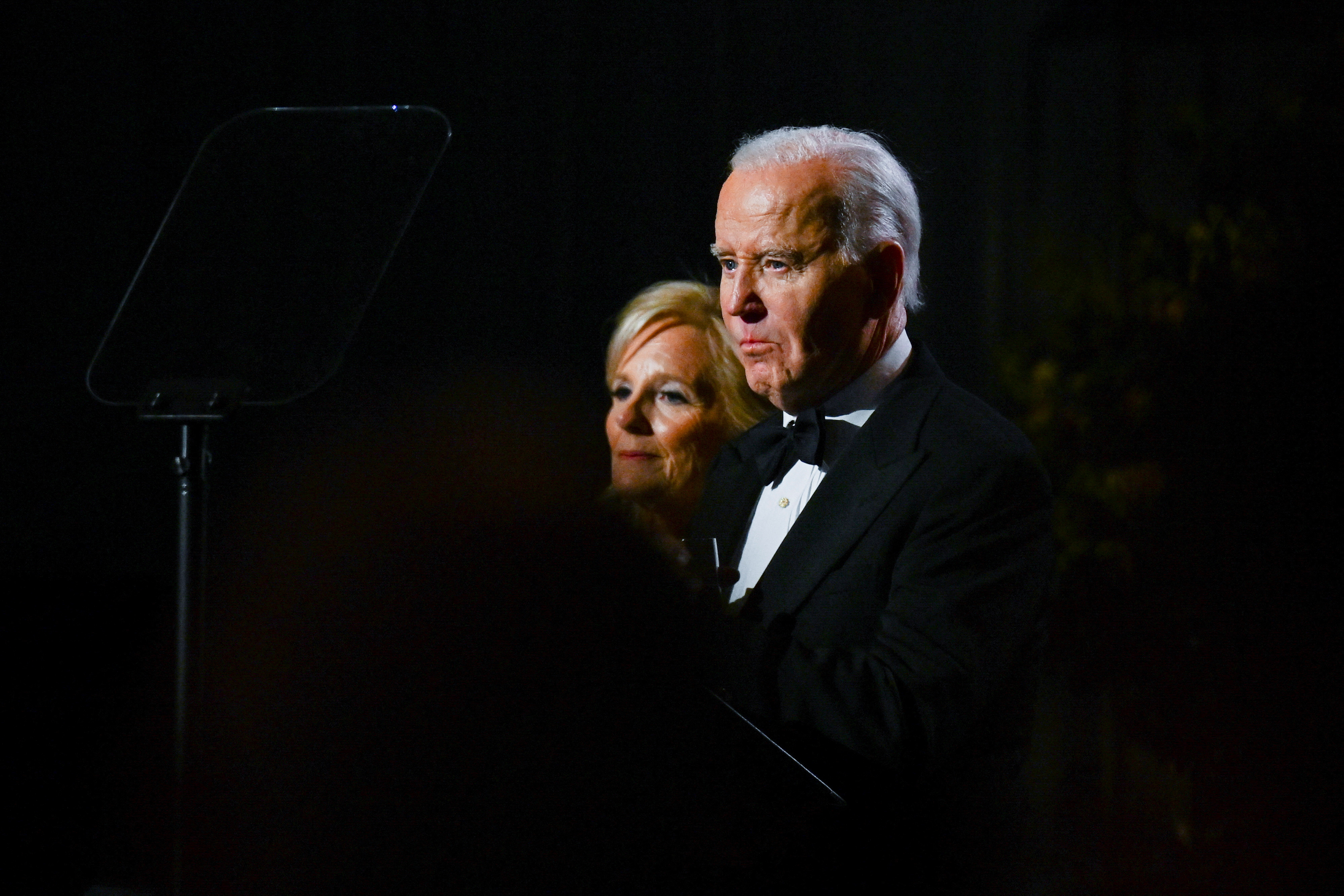 Joe Biden and Jill Biden, their faces lit in the dark.