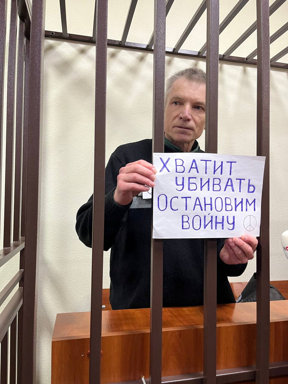 Moscow city councillor Alexei Gorinov, serving a seven-year sentence for criticising Russia's invasion of Ukraine, holds a placard reading "Stop killing. Let's stop the war" as he stands inside a defendants' cage during a new court hearing against him for "justifying terrorism", in Vladimir, Russia, November 27, 2024. Social Media/via REUTERS THIS IMAGE HAS BEEN SUPPLIED BY A THIRD PARTY. NO RESALES. NO ARCHIVES.