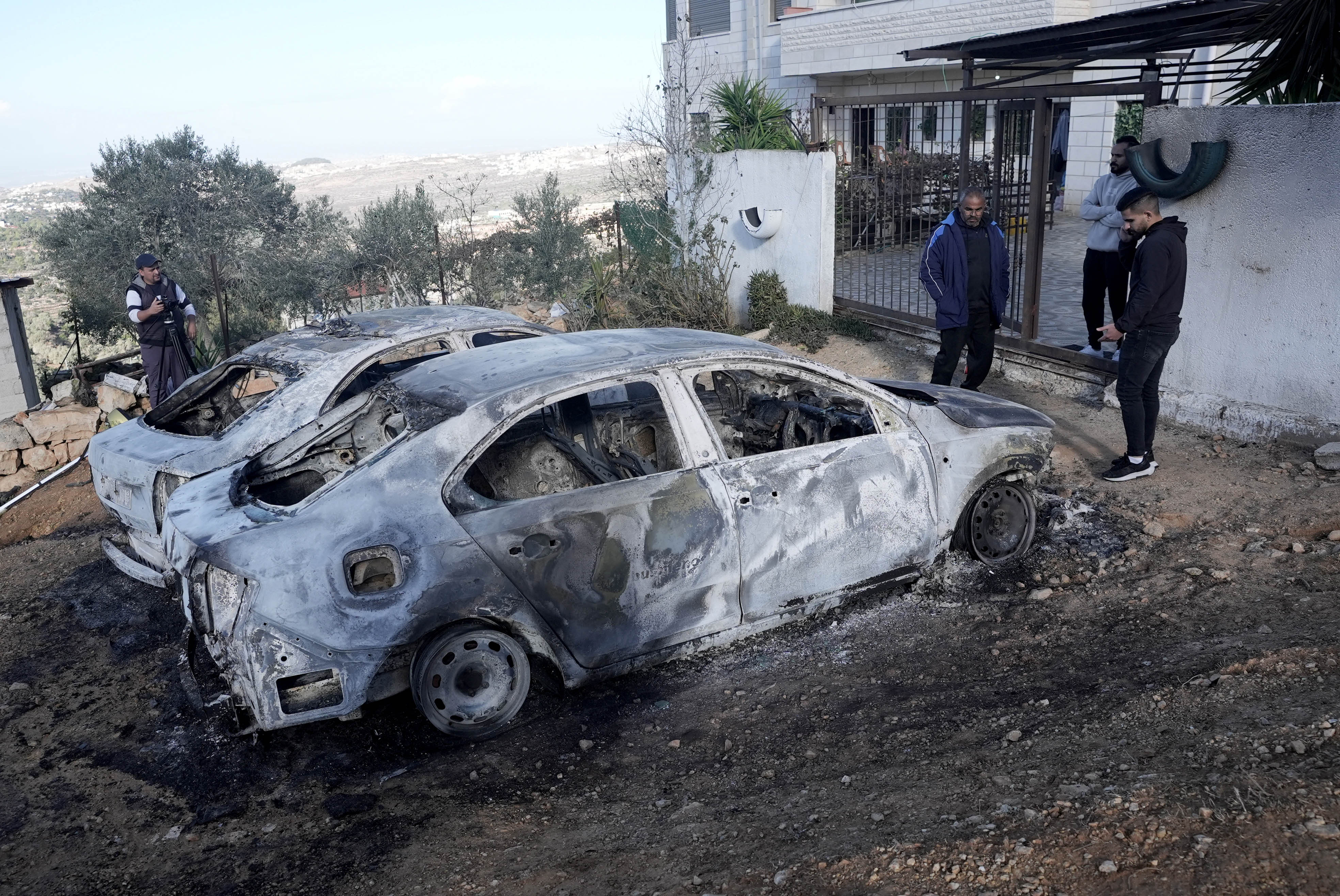 Palestinians inspect vehicles set on fire by Israeli settlers who raided the town of al-Mazra’a al-Qibliya near Ramallah, West Bank on November 20, 2024