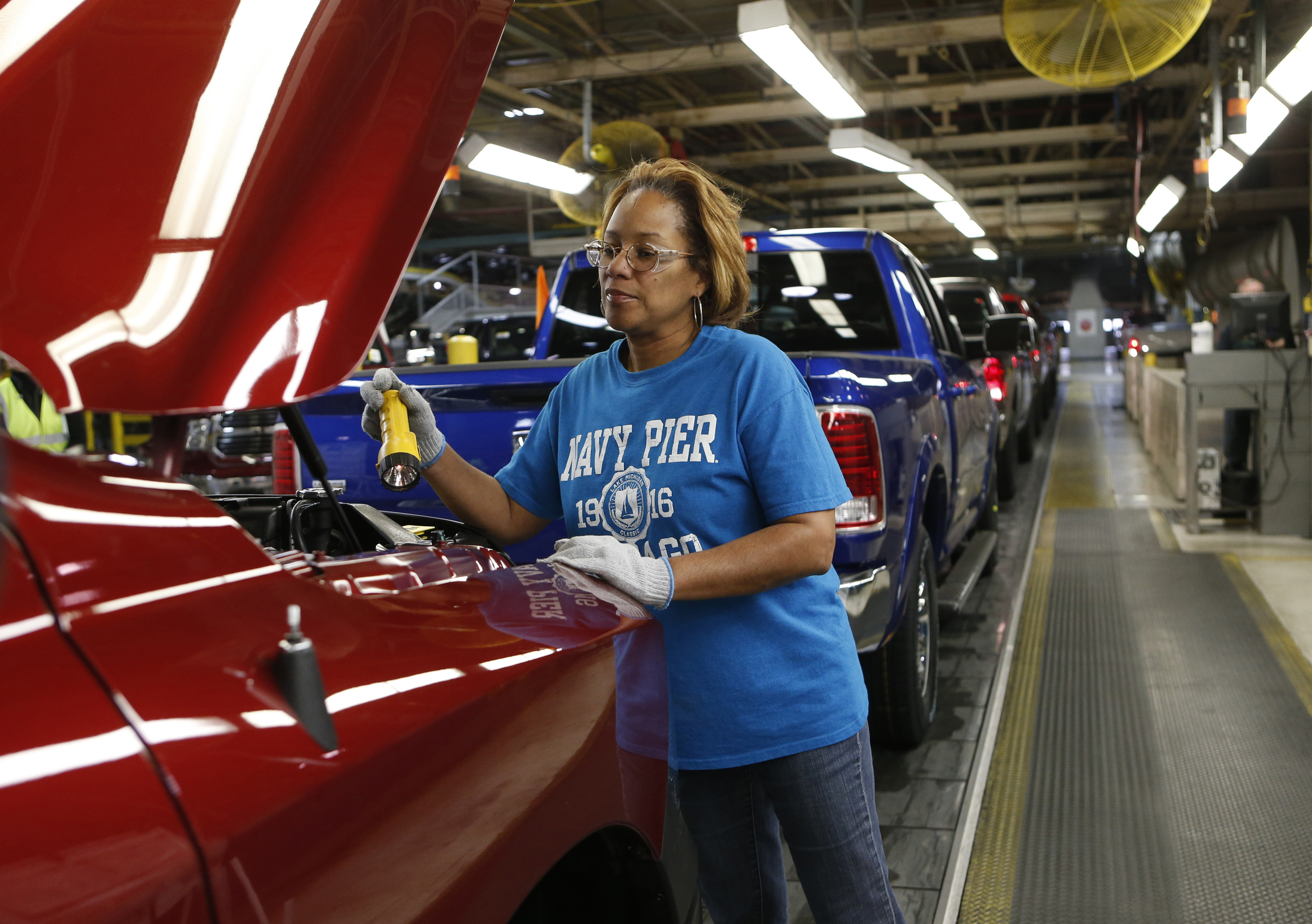 A worker checks under the hood of a pick-up truck for quality control at an assembly plant in the US state of Michigan in 2013
