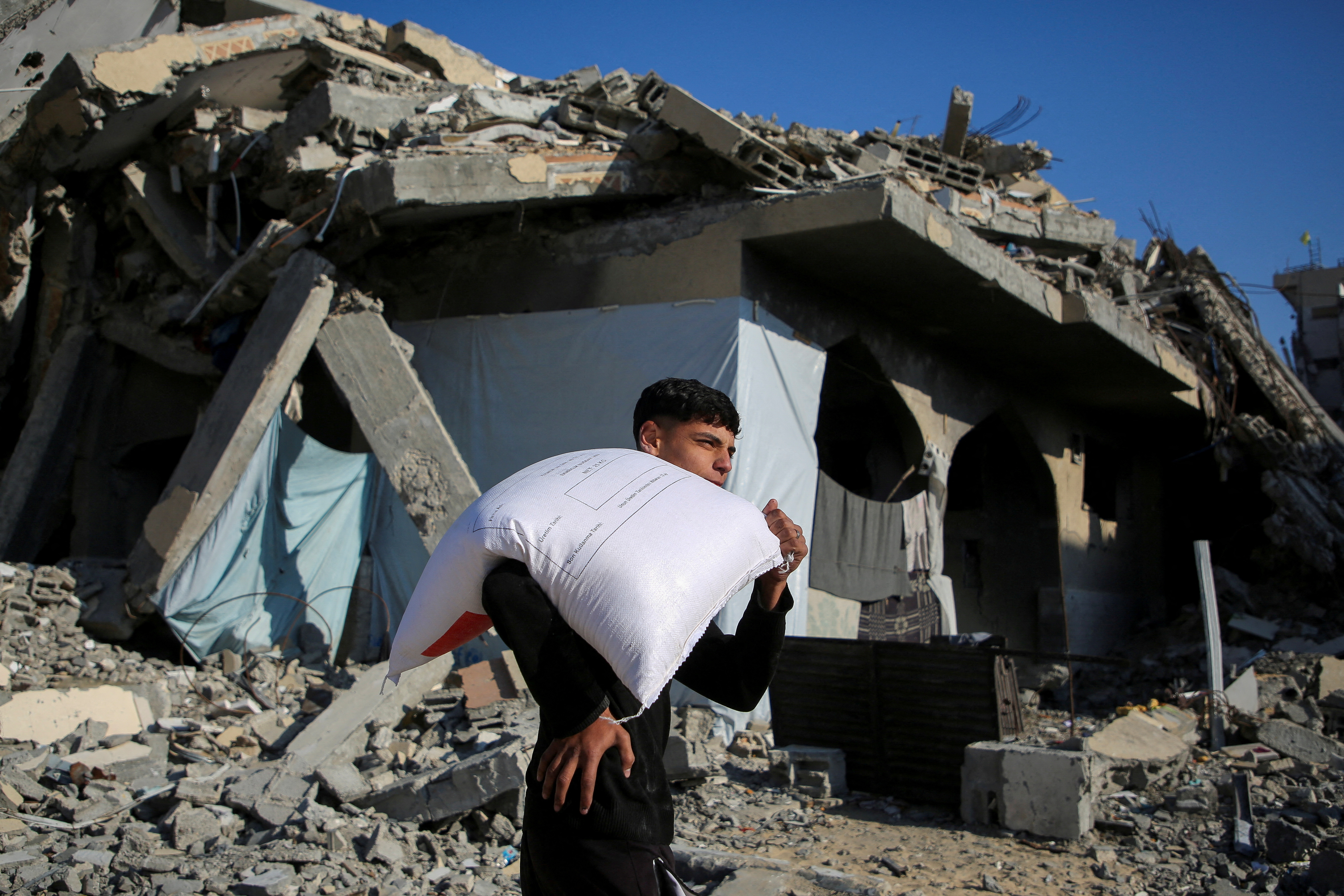 A man in Gaza carries a sack of flour