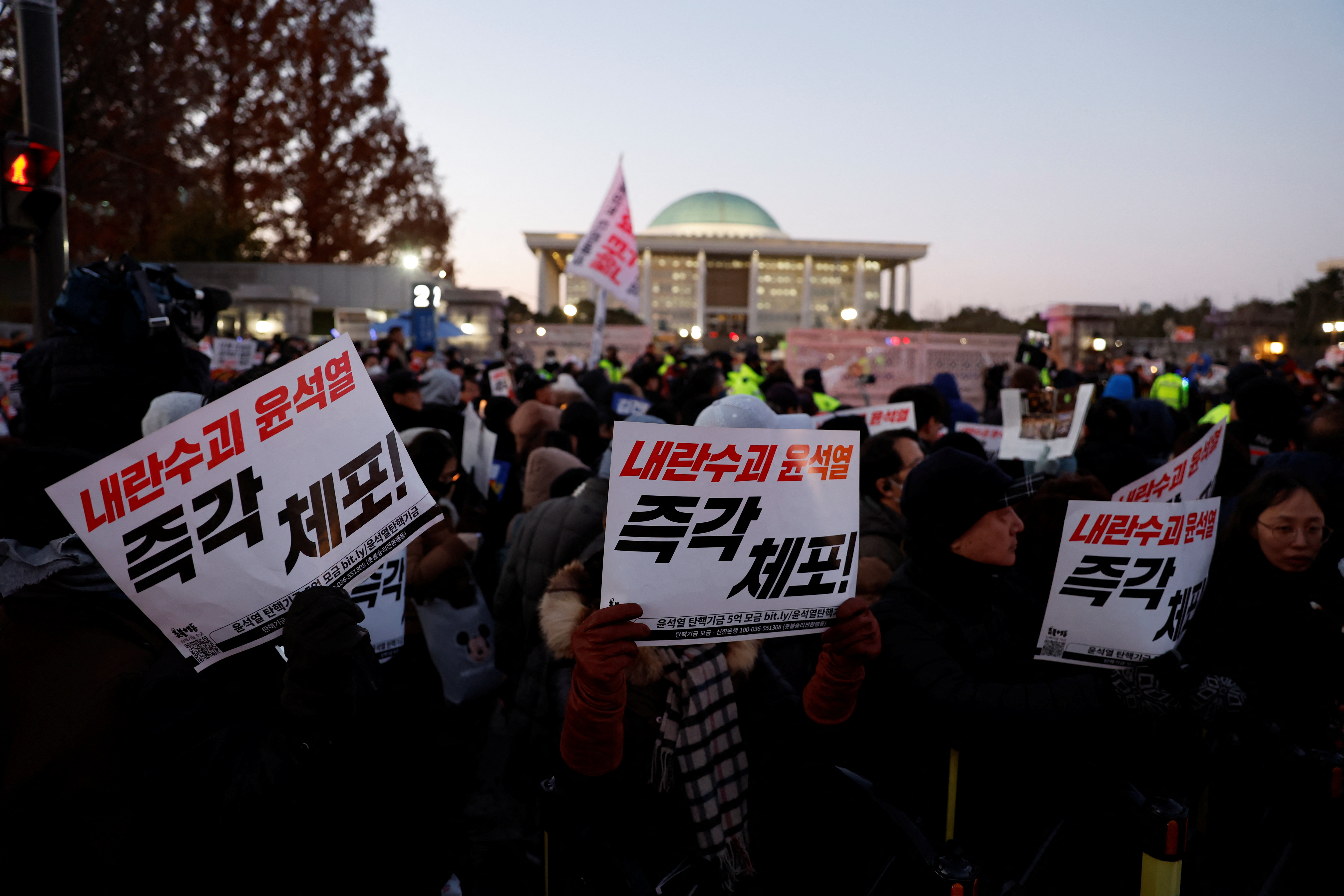 People hold banners that read 'Bind Yoon Suk Yeol right now' during a rally to demand the resignation of South Korean President Yoon Suk Yeol, in front of the National Assembly in Seoul, South Korea, December 6, 2024.