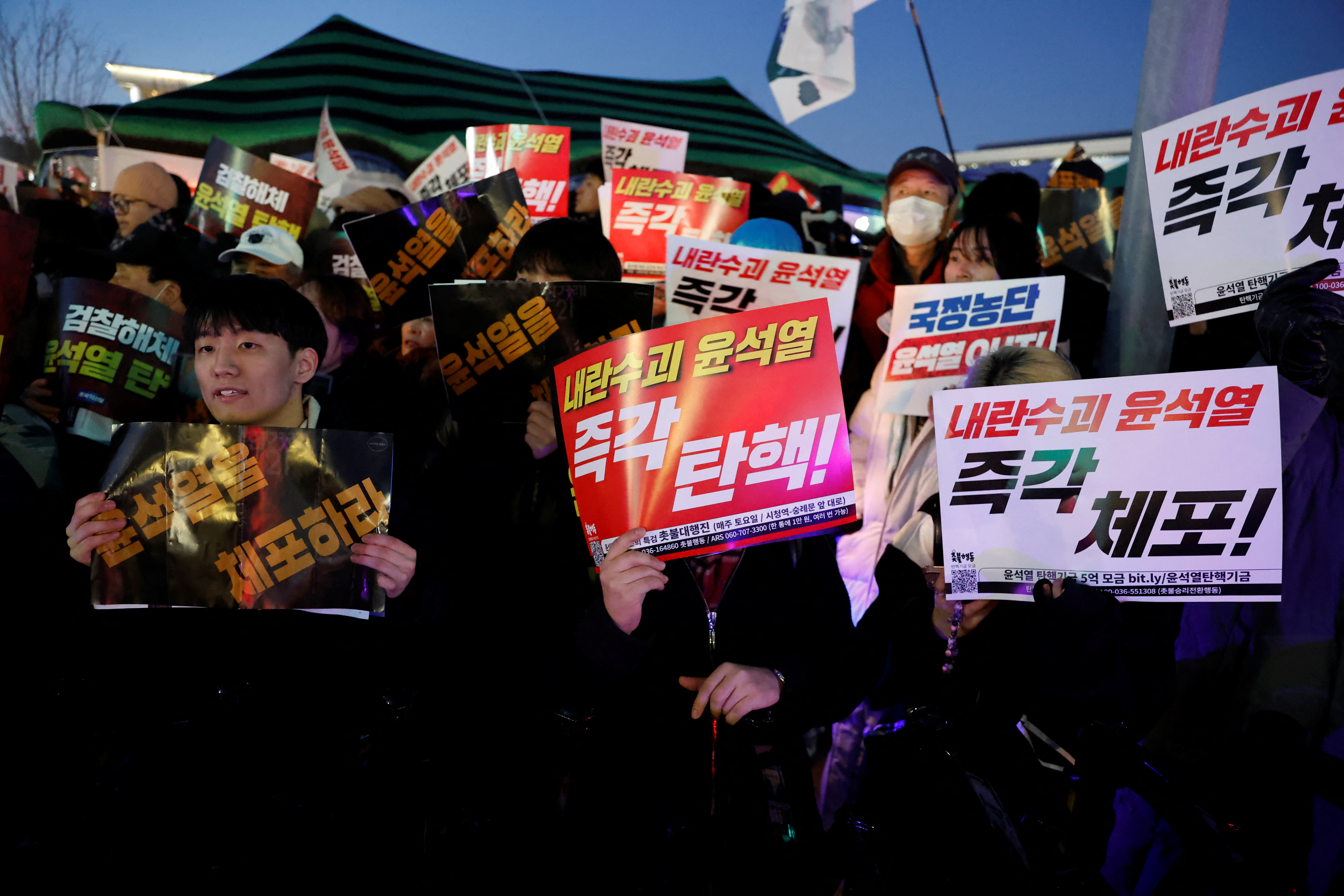People hold banners during a rally to demand the resignation of South Korean President Yoon Suk Yeol, in front of the National Assembly in Seoul, South Korea, December 6, 2024.