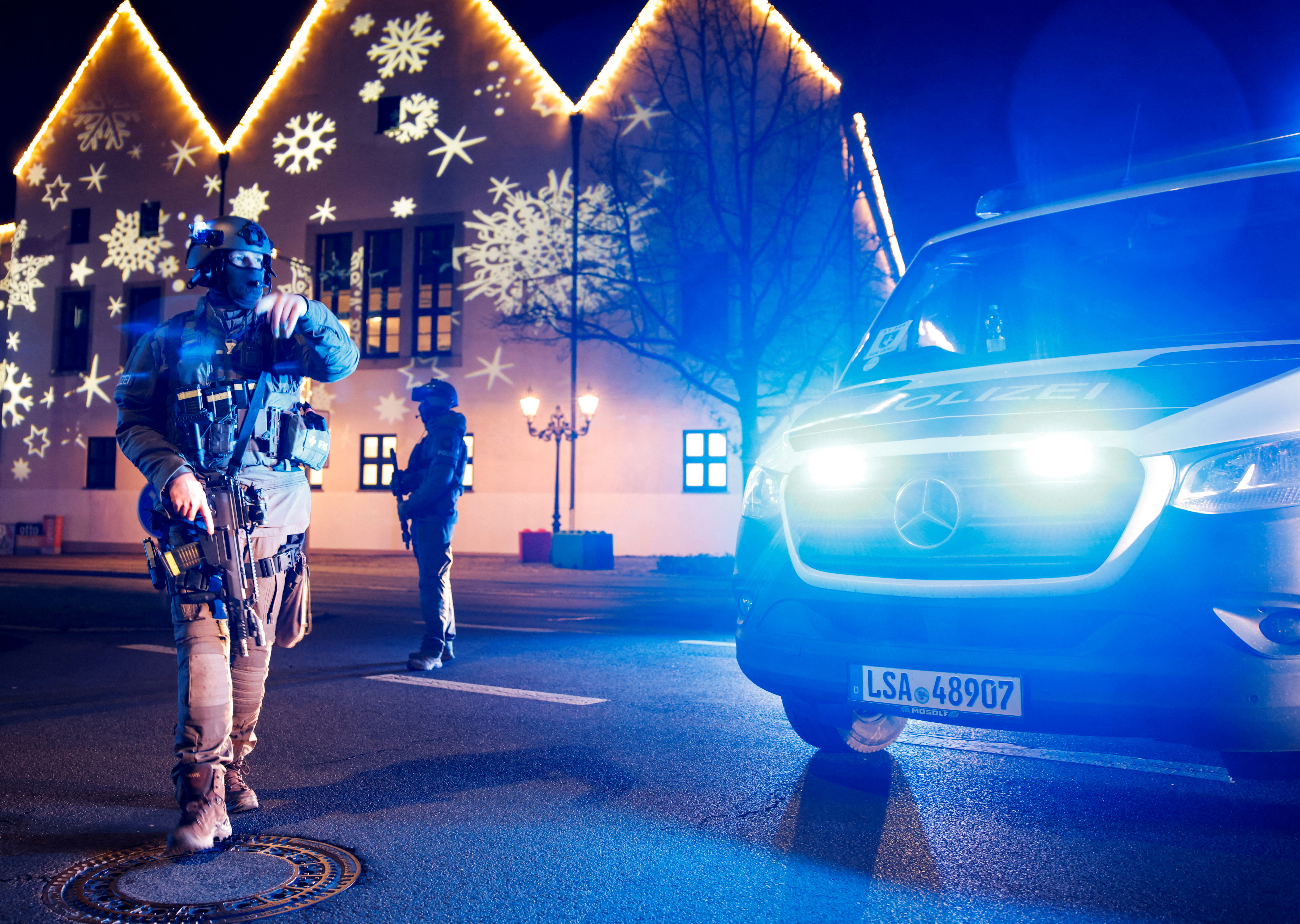 A police officer stands in front of decorations for a German Christmas market involved in an apparent attack.