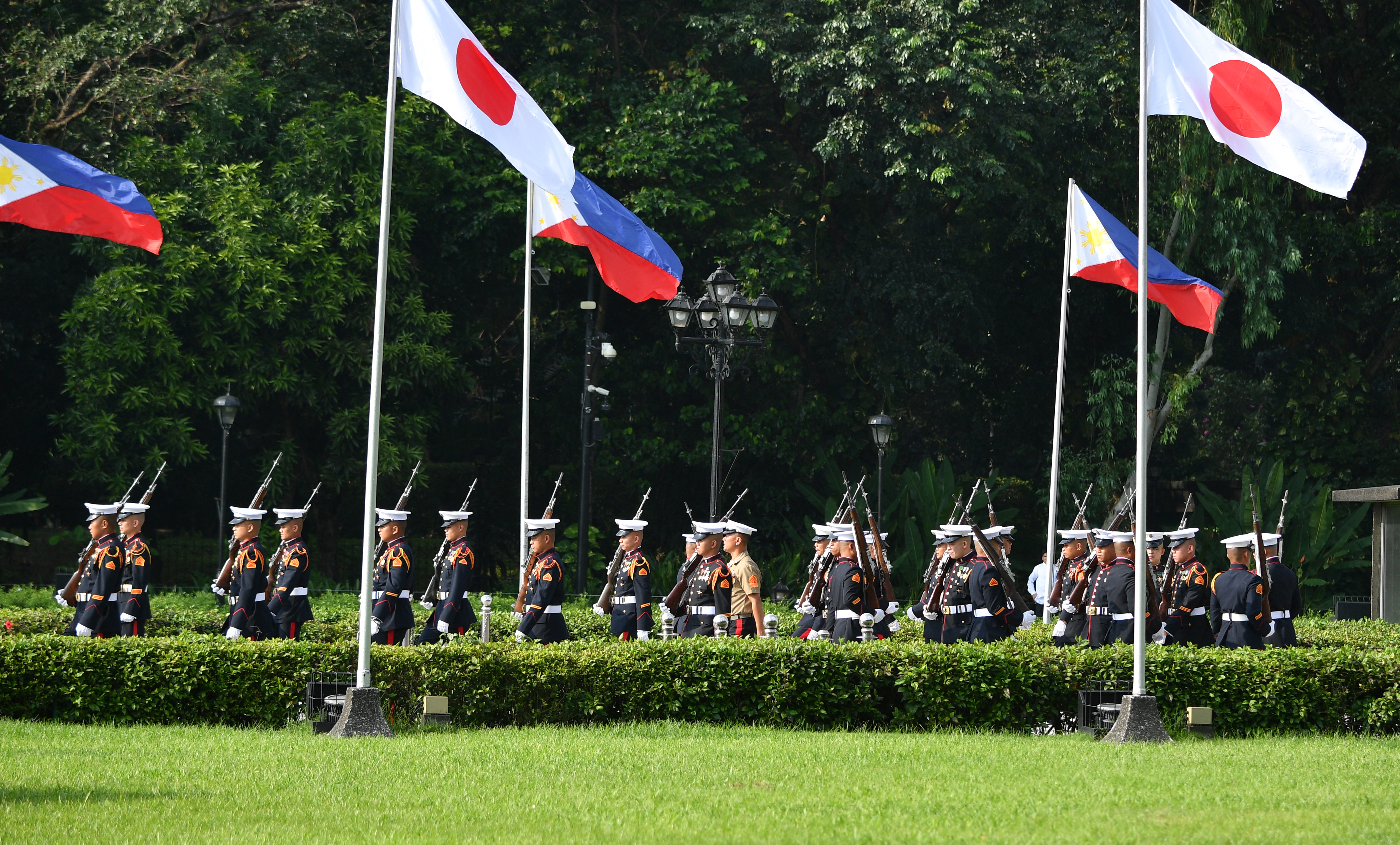 Philippine marines march between Philippine and Japanese flags prior to Japanese Prime Minister Fumio Kishida's (not pictured) arrival for a wreath-laying ceremony at Jose Rizal's monument in Manila on November 3, 2023
