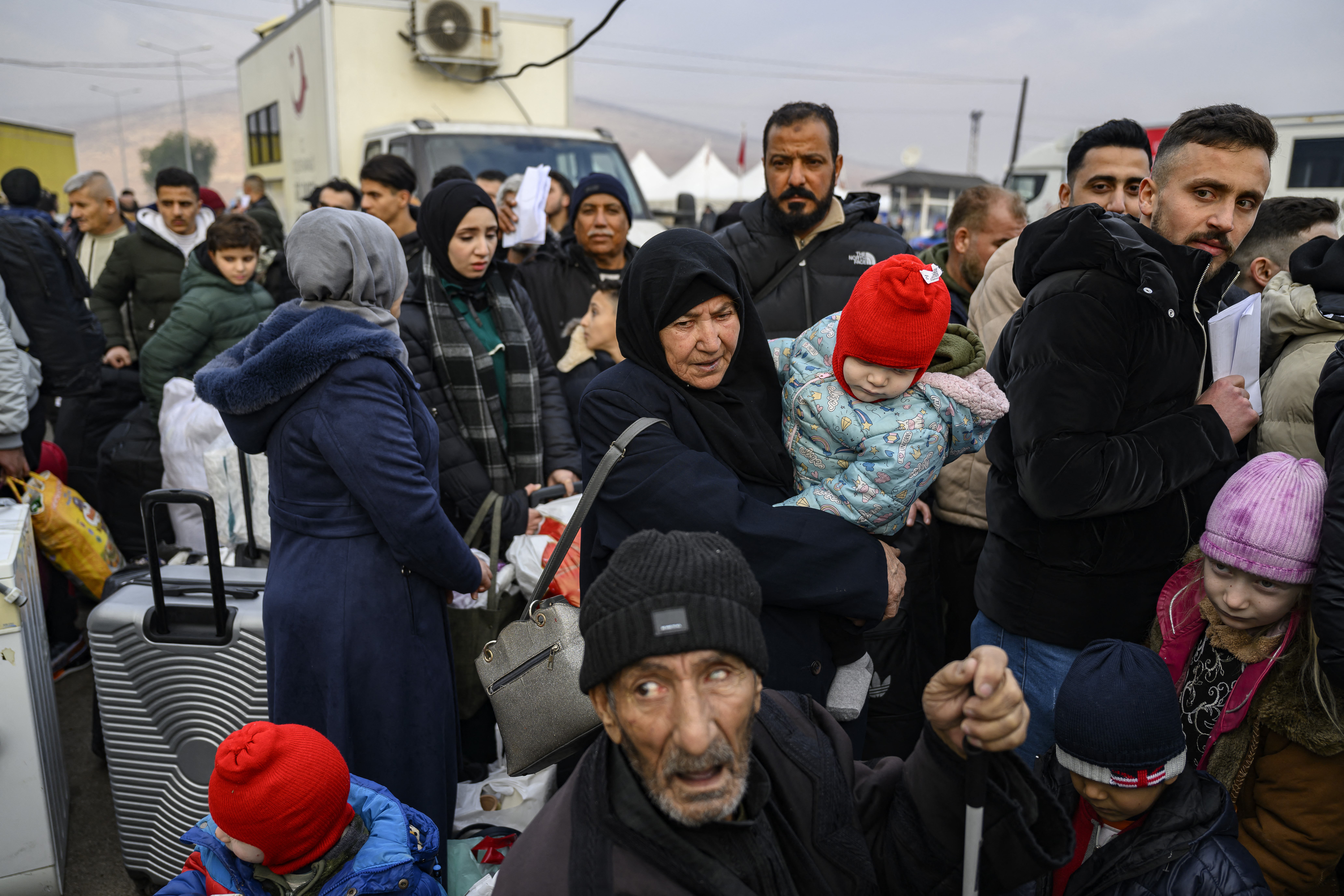 Syrian refugees living in Turkey wait in a queue to enter Syria