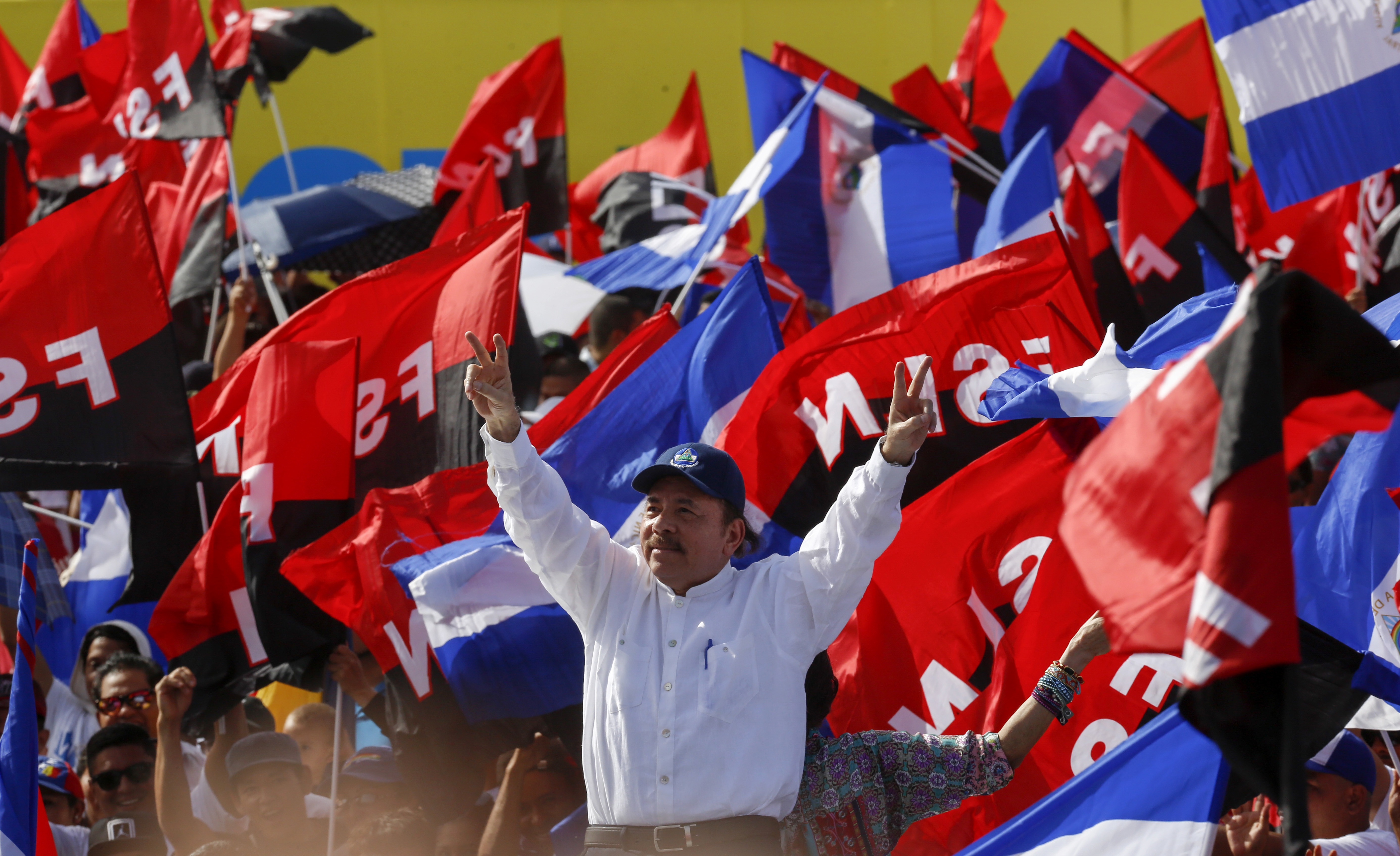 Daniel Ortega lifts his arms in celebration during a 2018 Sandinista rally.