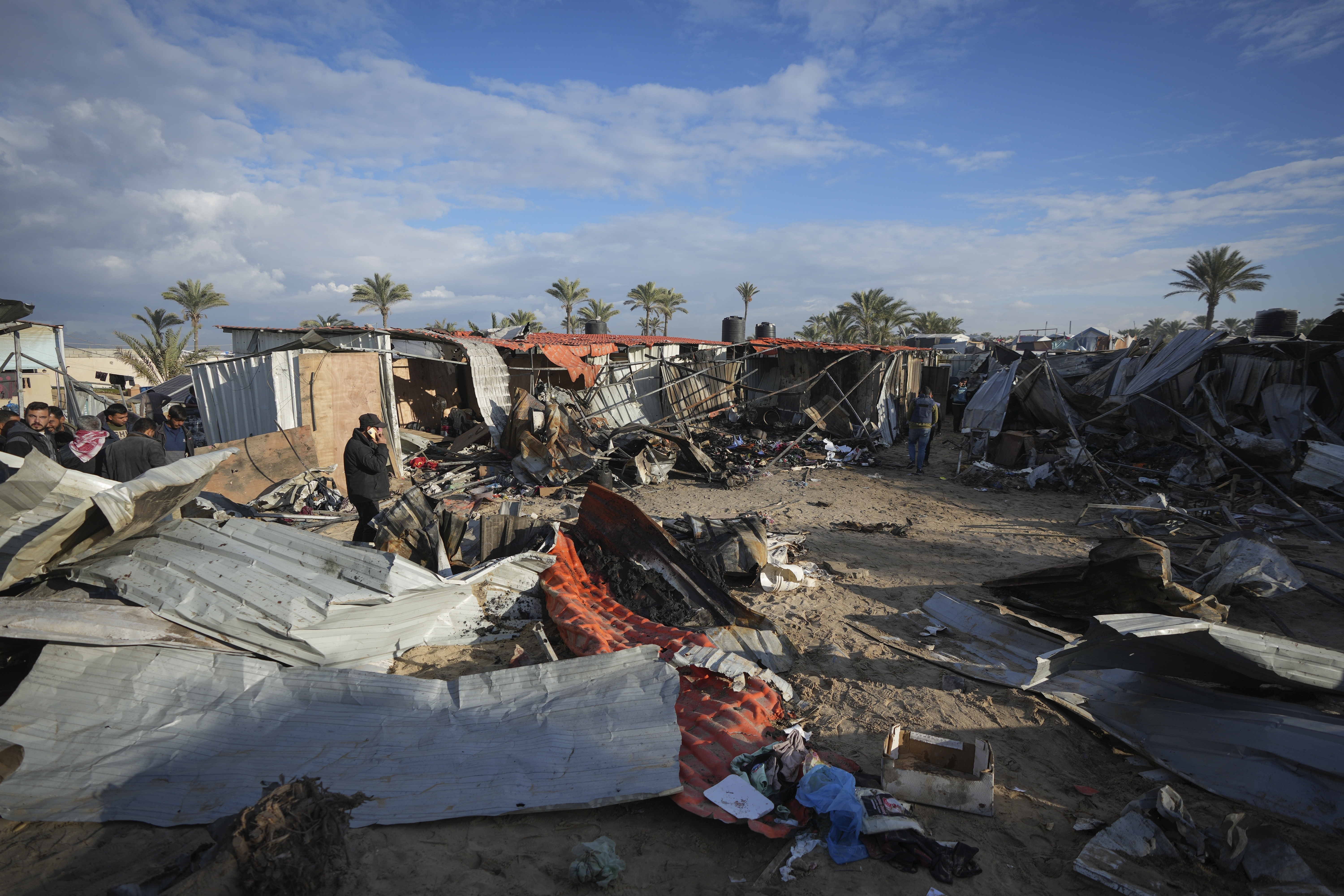 Palestinians survey the aftermath of an Israeli air strike at the al-Mawasi camp for displaced people near Khan Younis, in the southern Gaza Strip