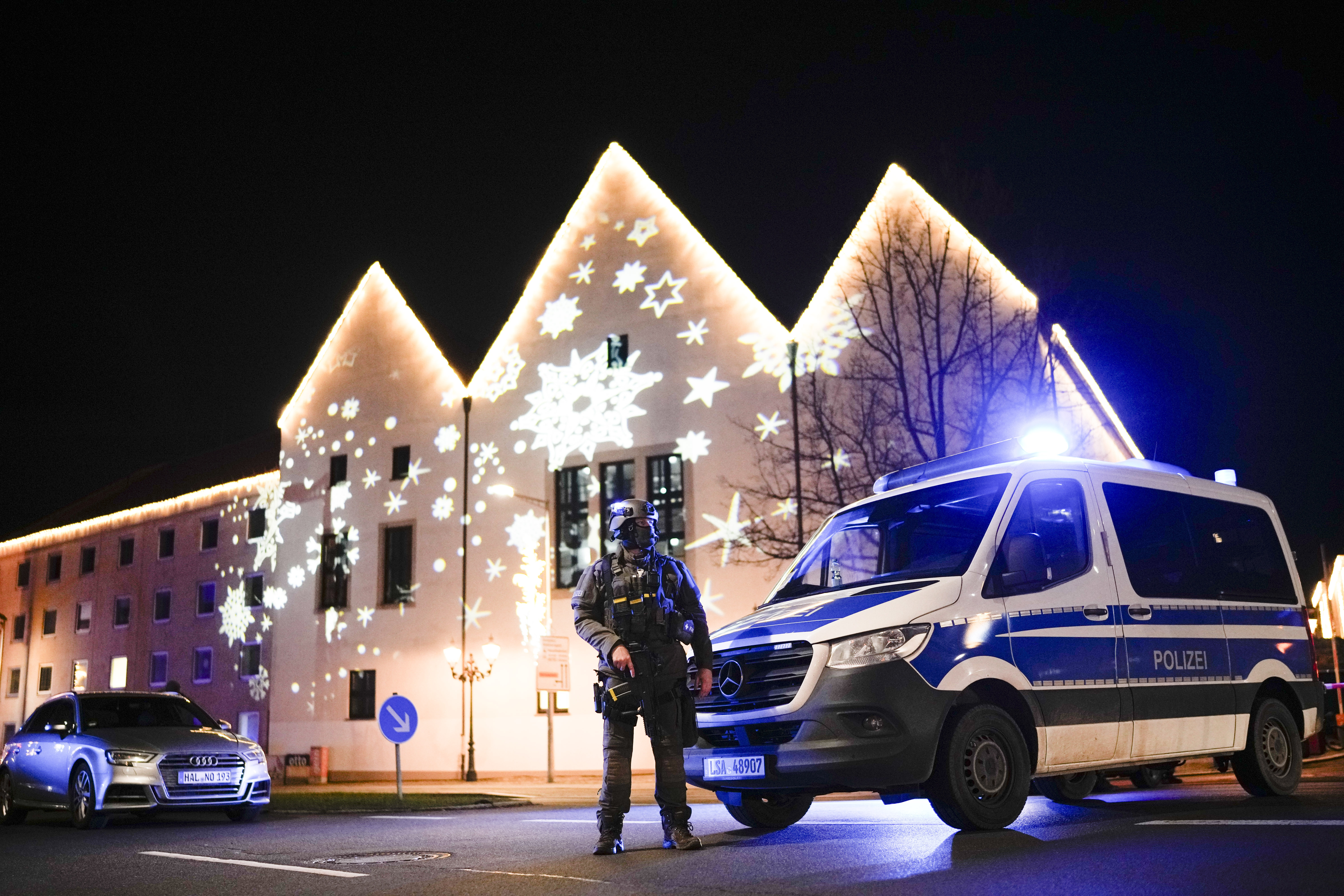 A police vehicle and officer near a Christmas market after a suspected attack in Magdeburg