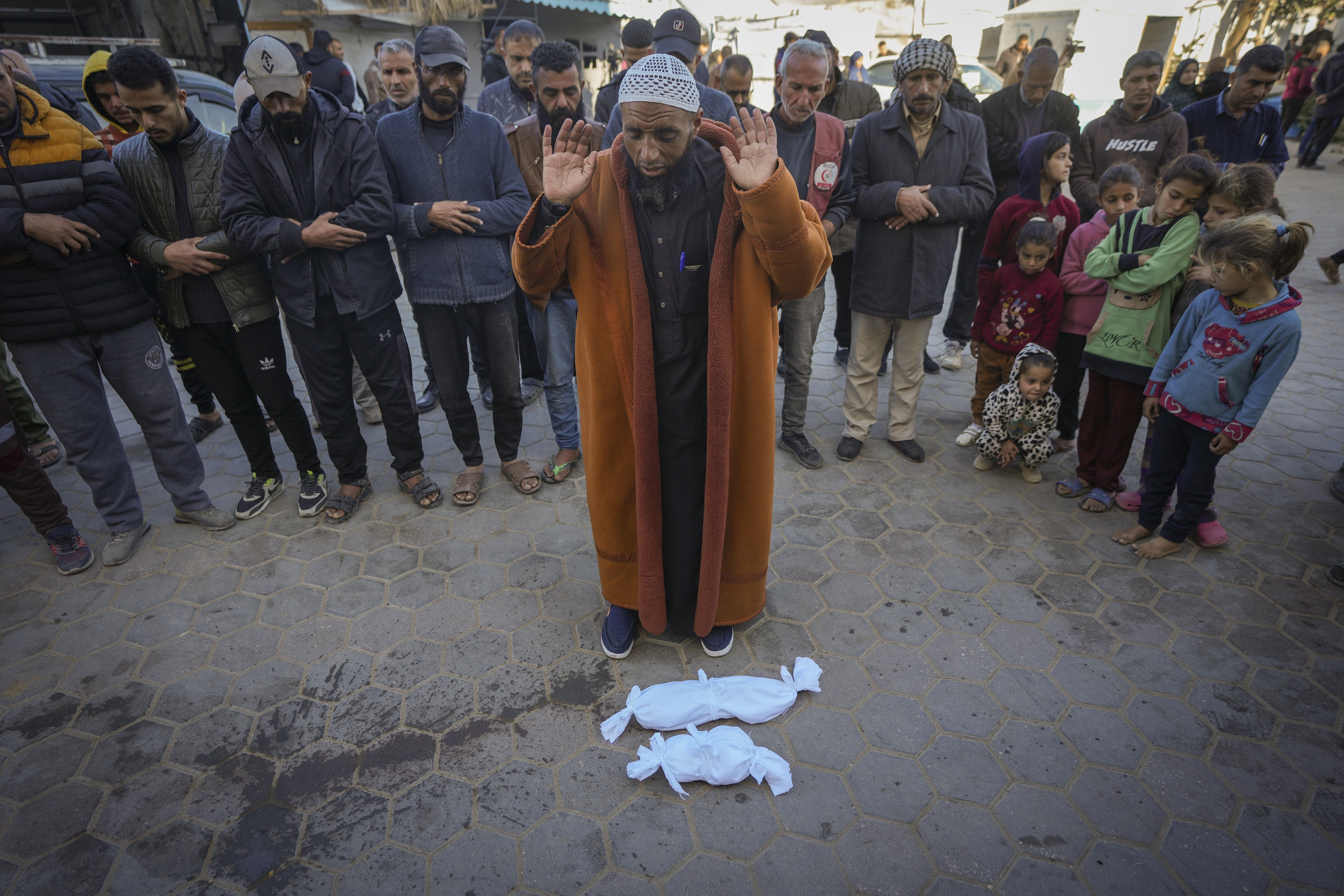 Imam Islam Abu Suaied prays over the bodies of Jumaa and another baby who died at birth at Al-Aqsa Martyrs Hospital in Deir el-Balah