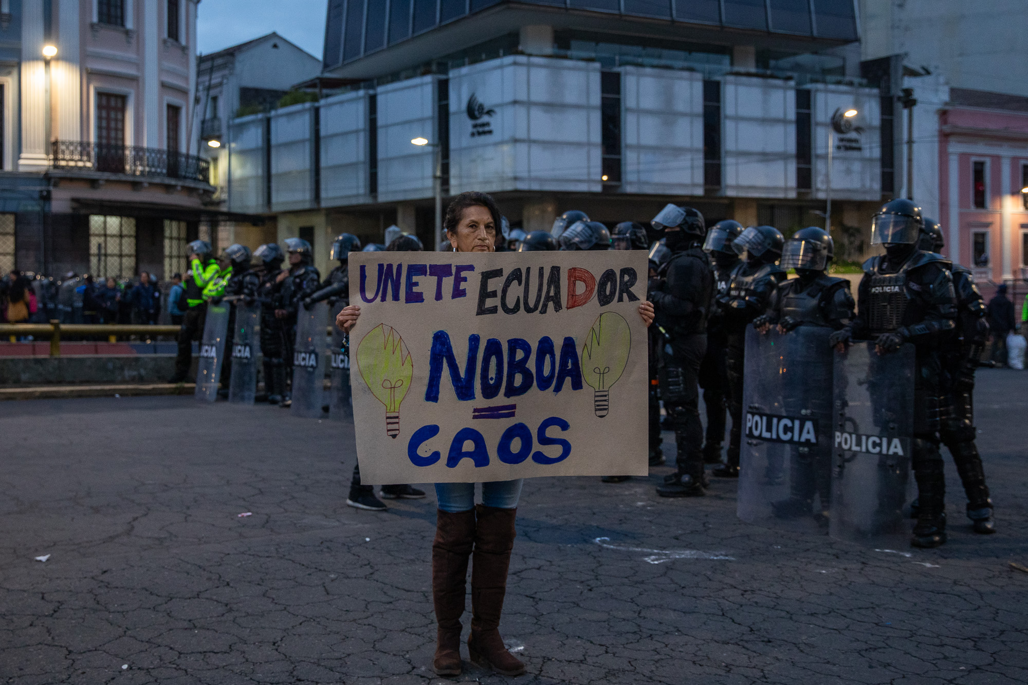 A protester in Ecuador holds up a handwritten sign with the words