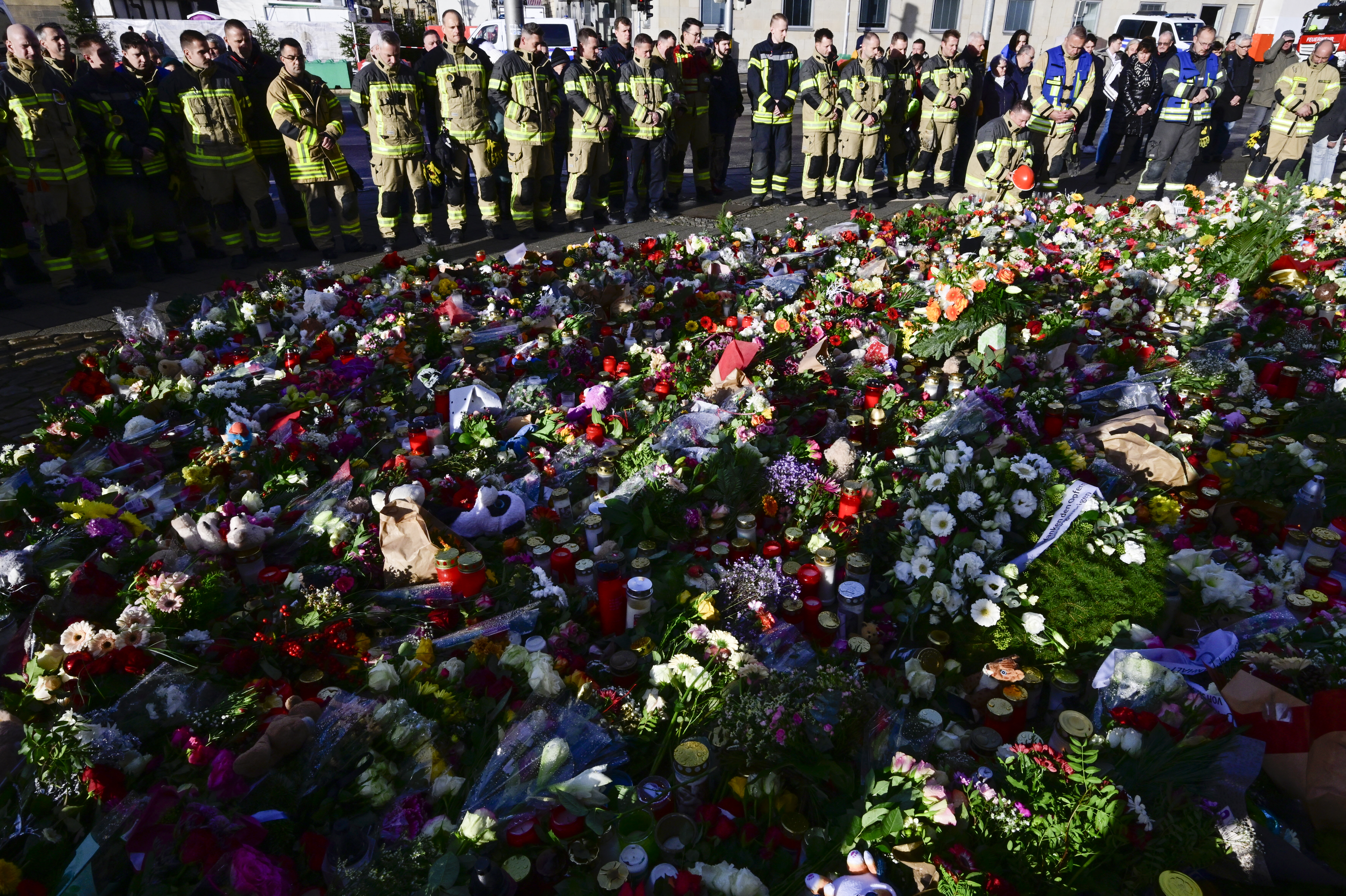 Members of Magdeburg's fire department stand at a makeshift memorial outside the Johanniskirche (Johannes Church)