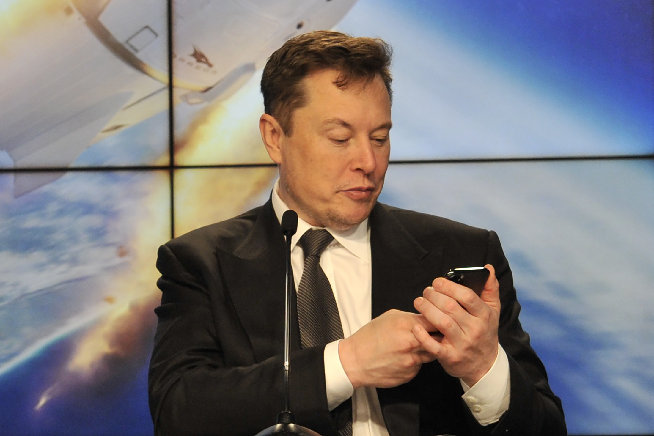 SpaceX founder and chief engineer Elon Musk looks at his mobile phone during a post-launch news conference to discuss the SpaceX Crew Dragon astronaut capsule in-flight abort test at the Kennedy Space Center in Cape Canaveral, Florida, U.S. January 19, 2020. REUTERS/Steve Nesius