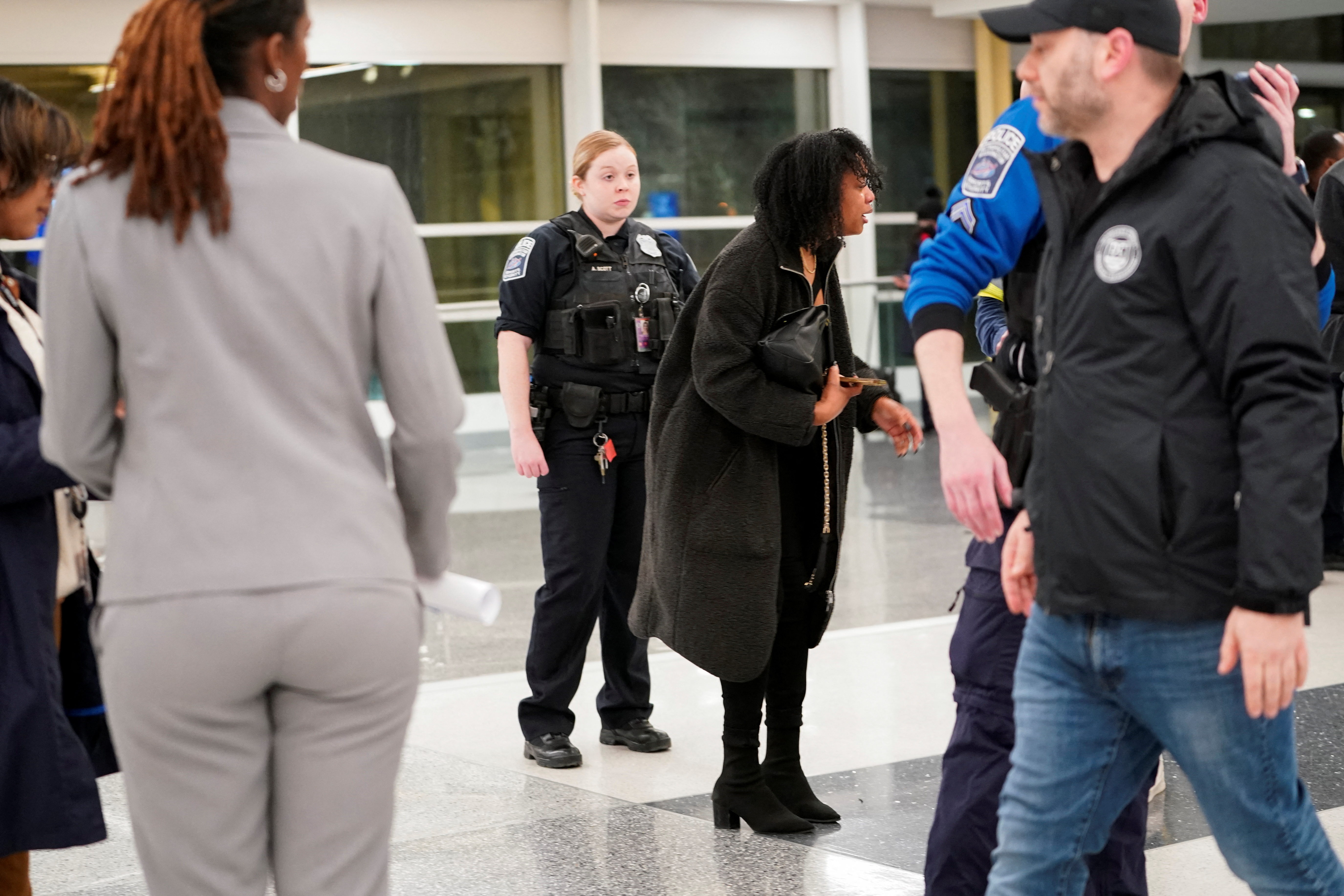 A woman at Ronald Reagan National Airport reacts to news that American Eagle flight 5342 collided with a helicopter, both crashing in the Potomac River, on January 29, 2025