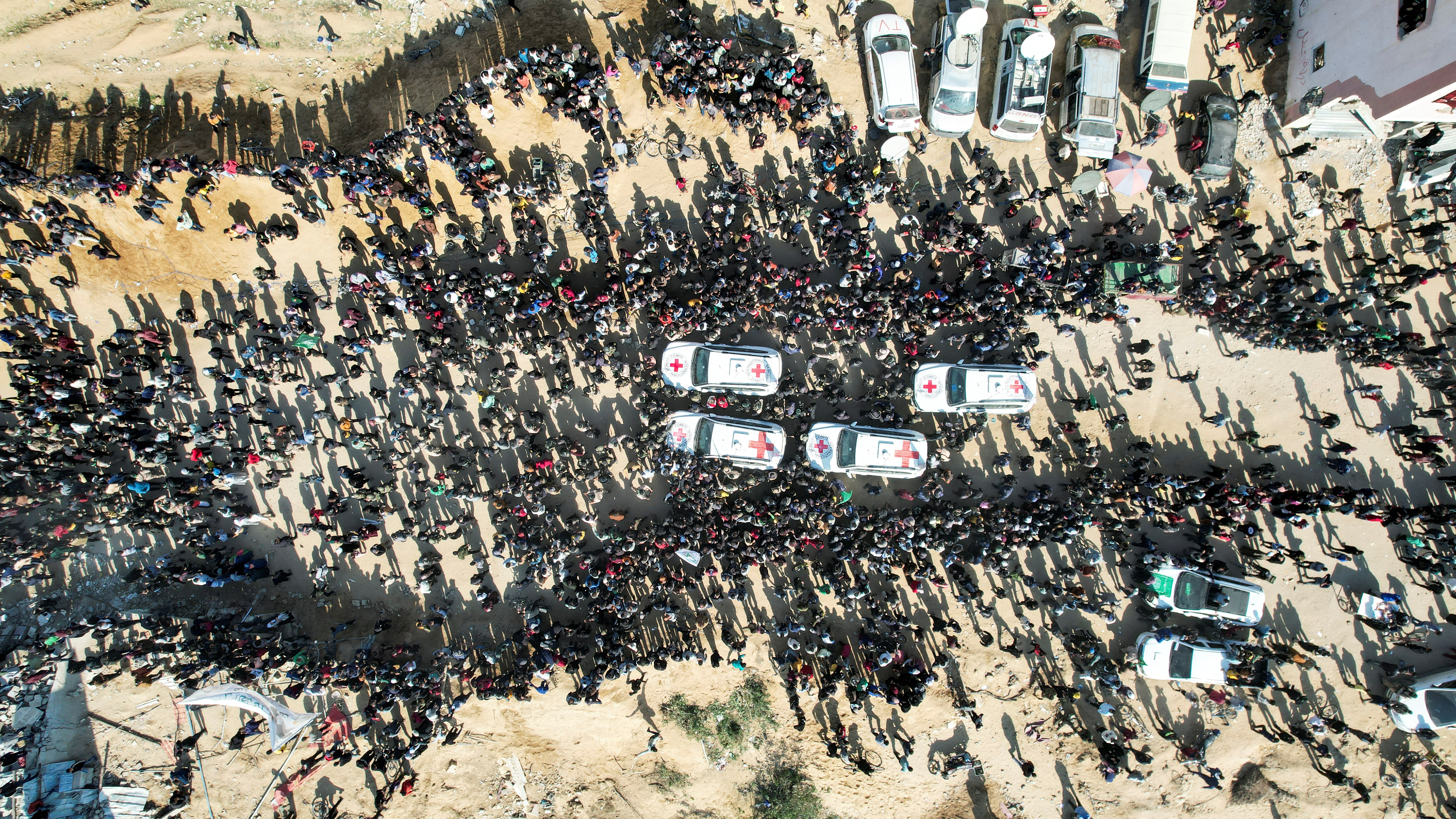 A drone view shows people gathering near vehicles of the International Committee of the Red Cross (ICRC) in Gaza