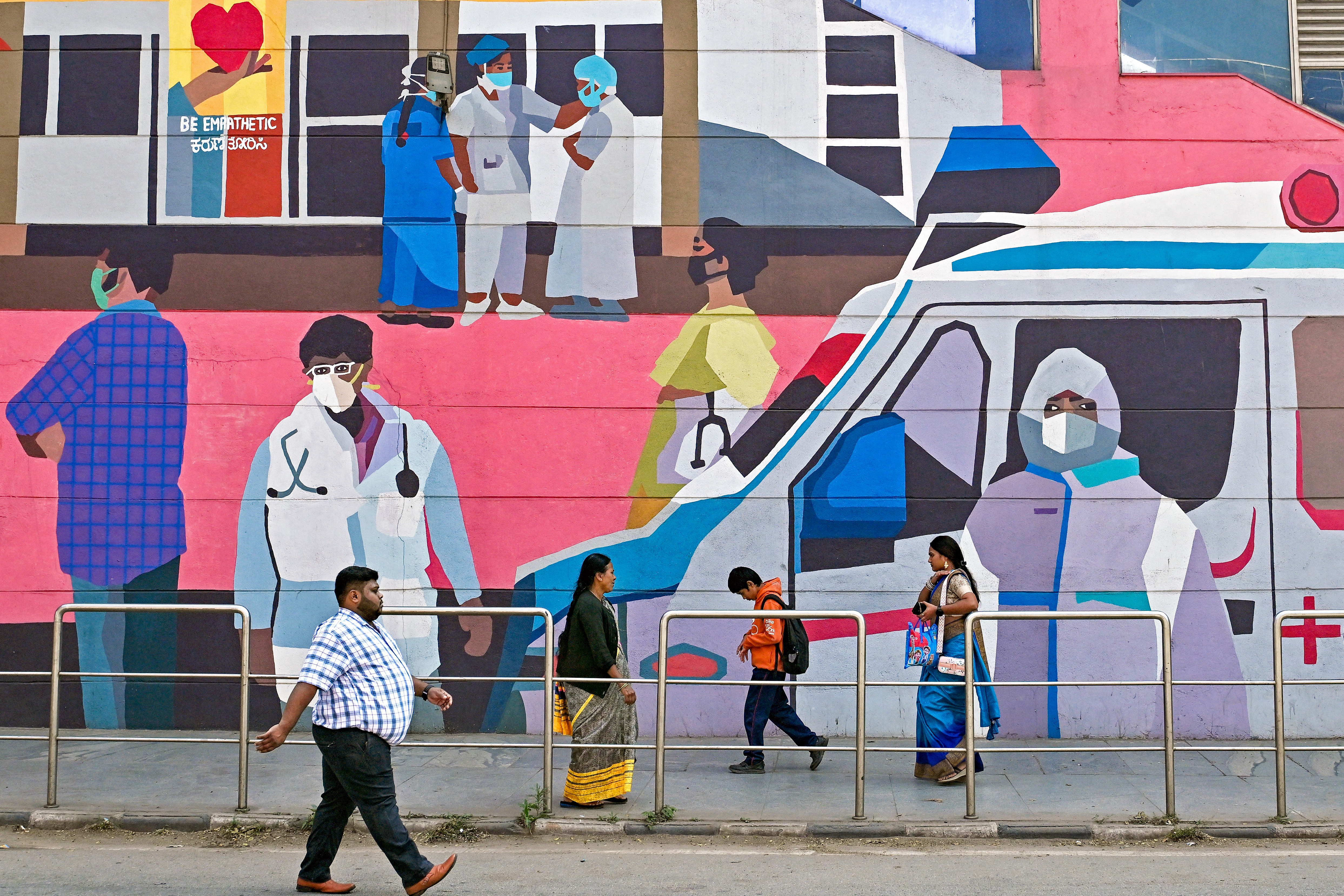 Pedestrians walk past a wall mural promoting awareness on using face masks in Bengaluru on January 6, 2025, amid concerns and alleged media reports stating that two cases of HMPV were detected in India’s Karnataka state.