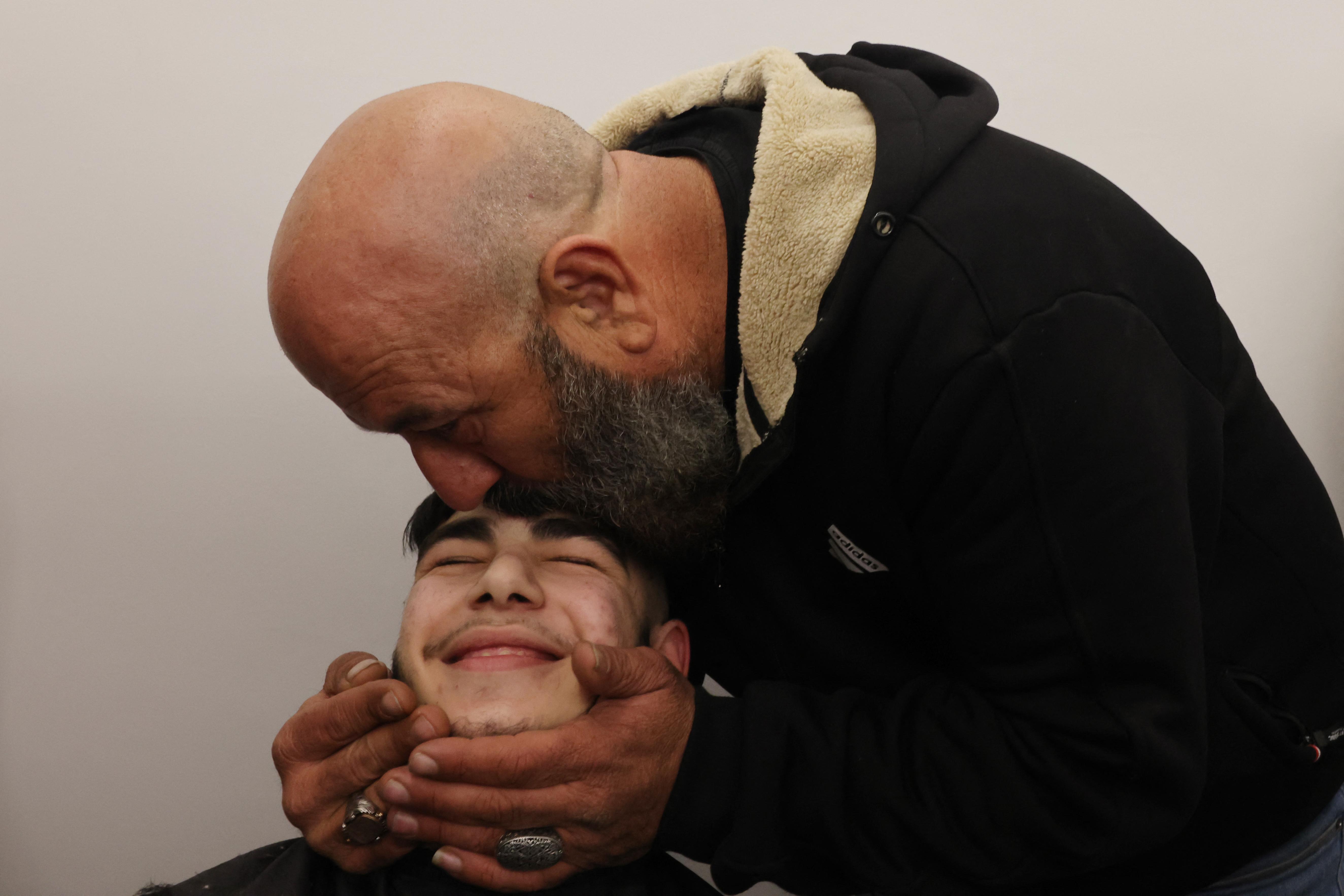 The uncle of 17-year-old Palestinian prisoner Qassem Jaafra kisses his forehead upon his arrival home in the Silwan neighbourhood in east Jerusalem following his release in the early hours of January 20, 2025 along with 90 other Palestinian prisoners.