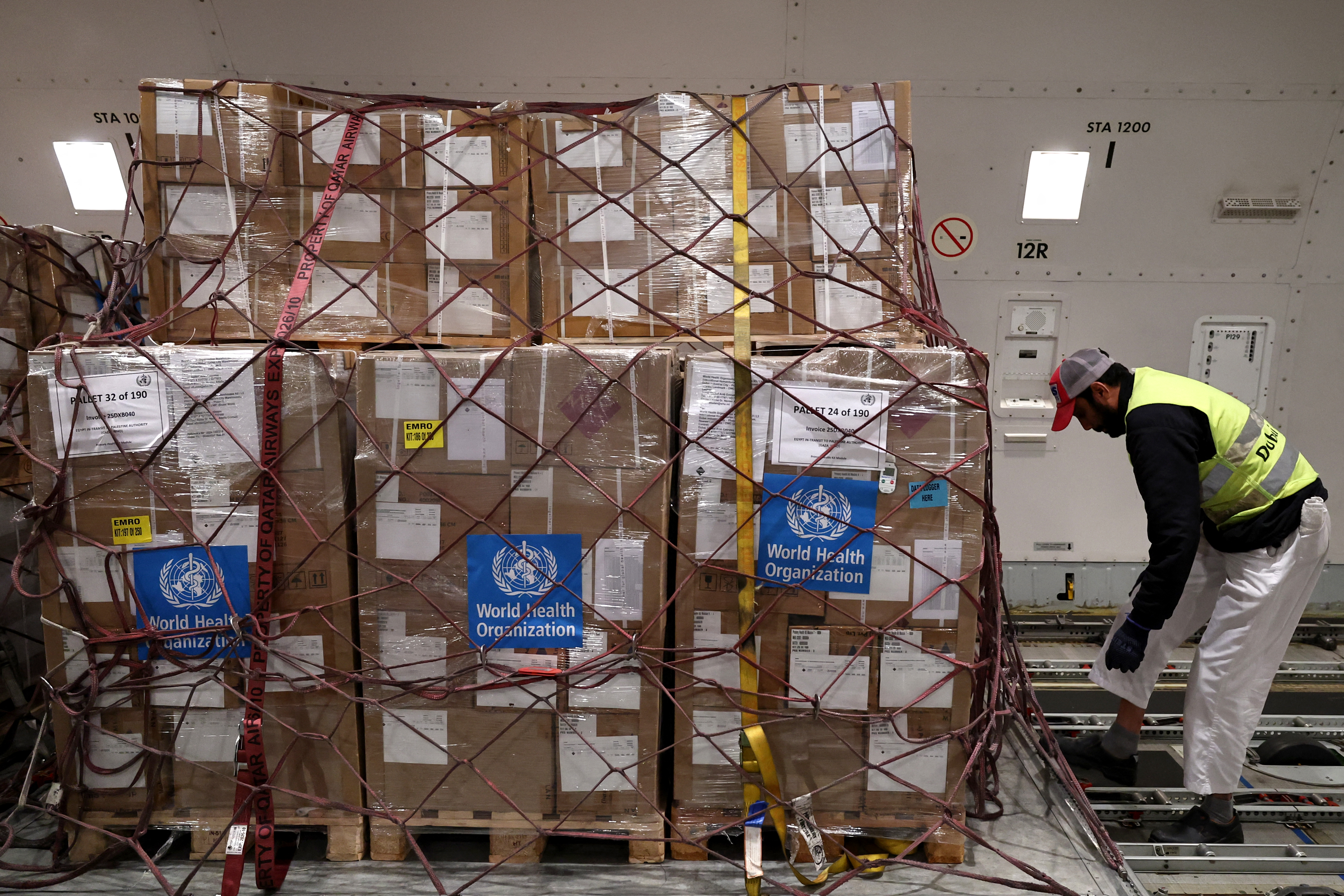 A worker arranges UN's World Health Organisation (WHO) humanitian aid in a UAE plane headed to Egypt's El-Arish airport on January 24, 2025 at an airport in Dubai, as part of a humanitarian mission organised by the United Arab Emirates to deliver humanitarian assistance in the Gaza Strip after a ceasefire deal in the war between Israel and Hamas. (Photo by Fadel Senna / AFP)