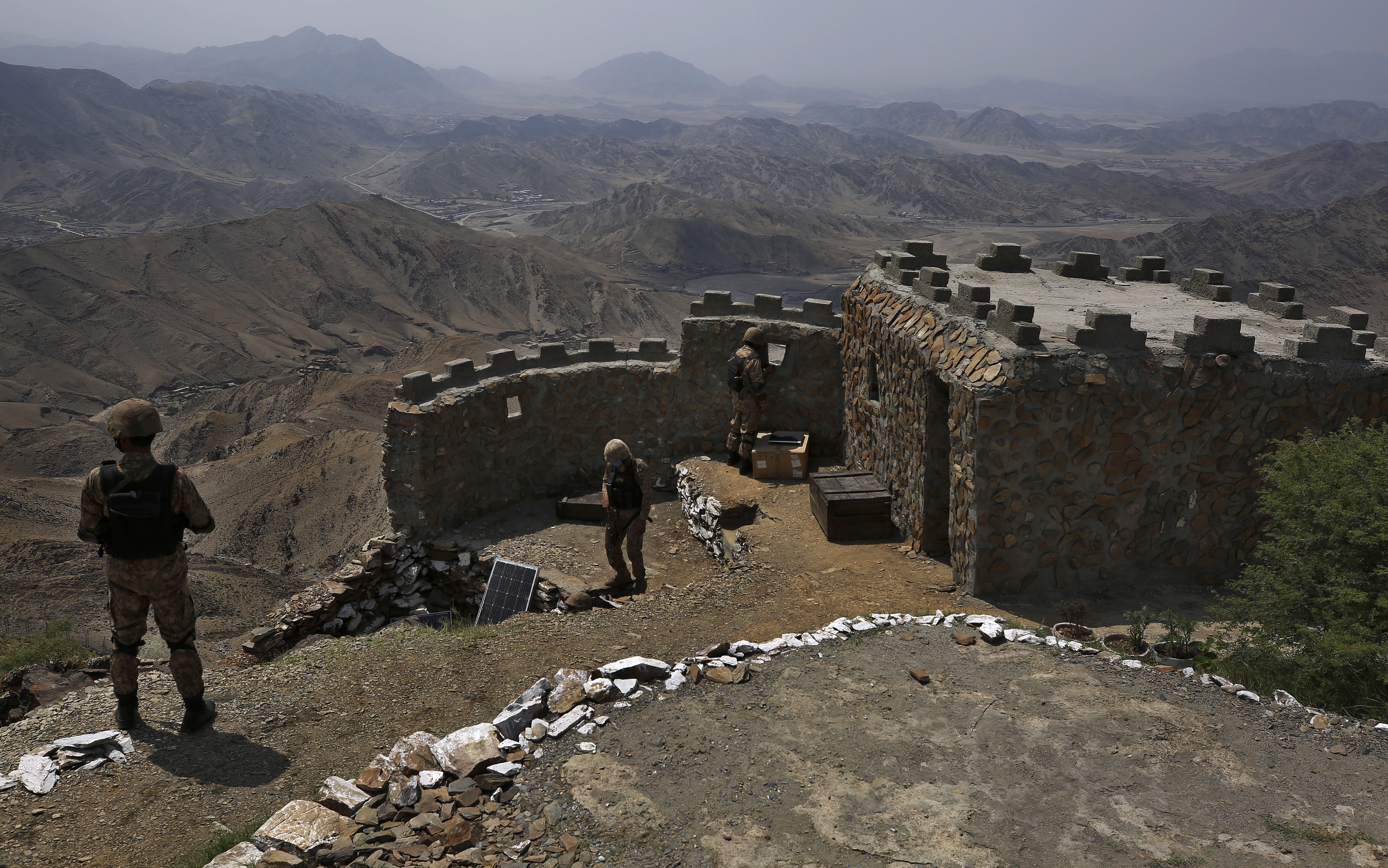 FILE - In this Aug. 3, 2021 file photo, Pakistan Army troops observe the area from hilltop post on the Pakistan Afghanistan, in Khyber district, Pakistan. Pakistani authorities Monday, Nov. 8, 2021 announced a month-long cease-fire with a key militant group behind numerous attacks on security forces and civilians over the last 14 years. Government spokesman Fawad Chaudhry said on Twitter that the Taliban government in Afghanistan helped facilitate the cease-fire between the government of Prime Minister Imran Khan and the Tehrik-e-Taliban Pakistan, or TTP. (AP Photo/Anjum Naveed, File)