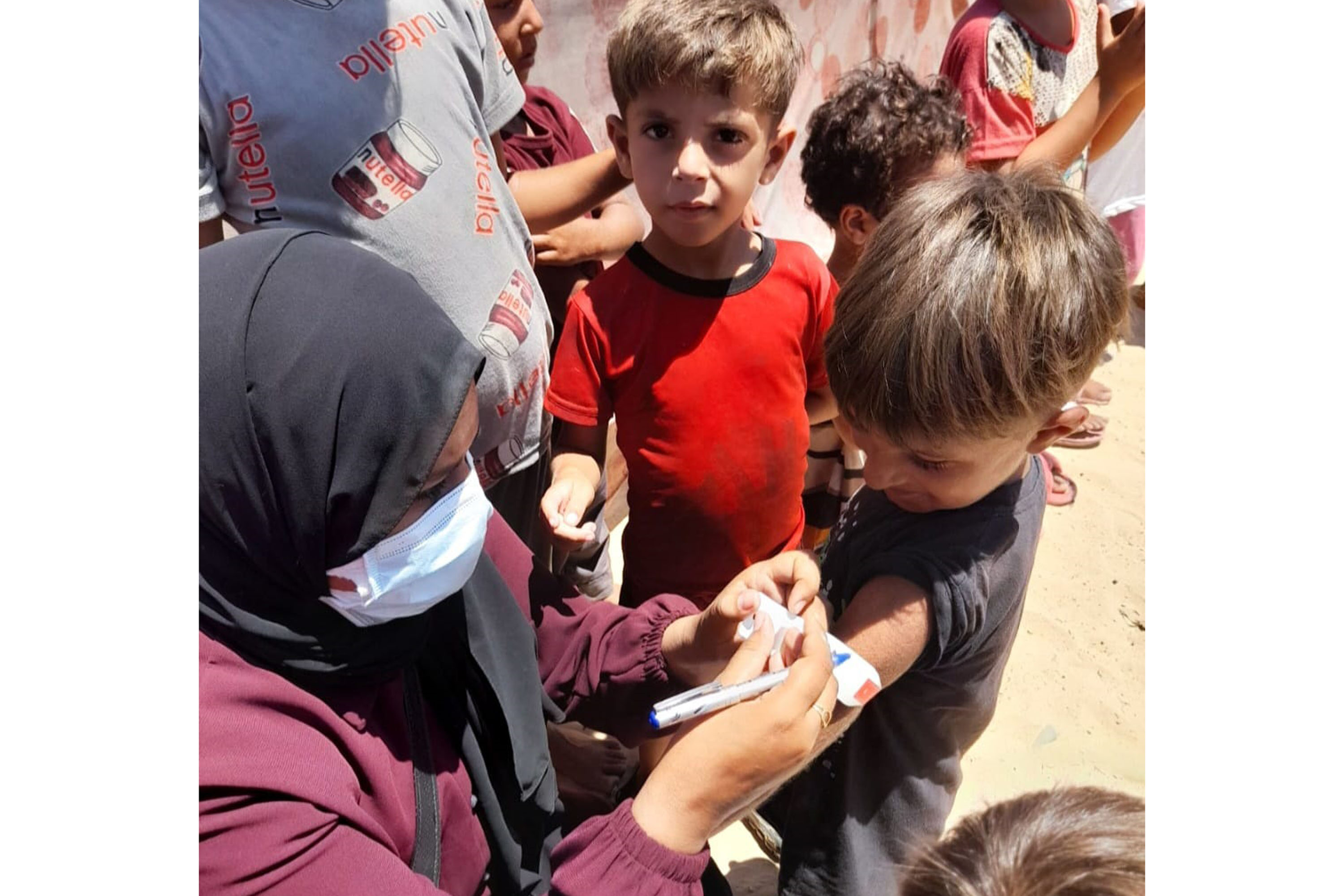 a photo of a nurse measuring the arm circumference of a child