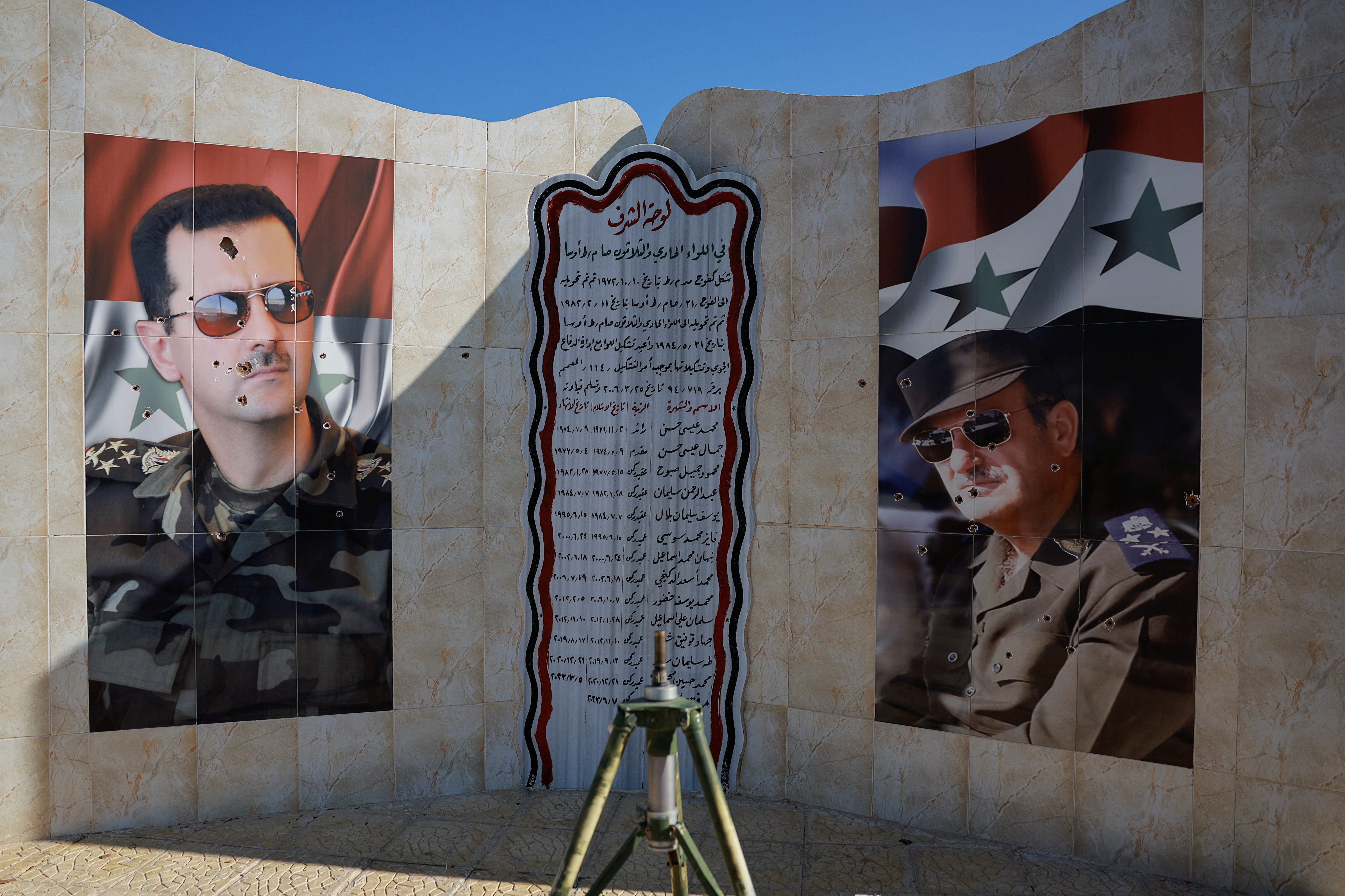 Images of Syria's Bashar al-Assad and former Syrian President Hafez al-Assad are damaged by bullet holes, as fighters of the ruling Syrian body inspect the damage at a military site, in the aftermath of an Israeli strike according to Syrian Observatory for Human Rights, after fighters of the ruling Syrian body ousted Syria's Bashar al-Assad, in Damascus, Syria, December 14, 2024. REUTERS/Ammar Awad