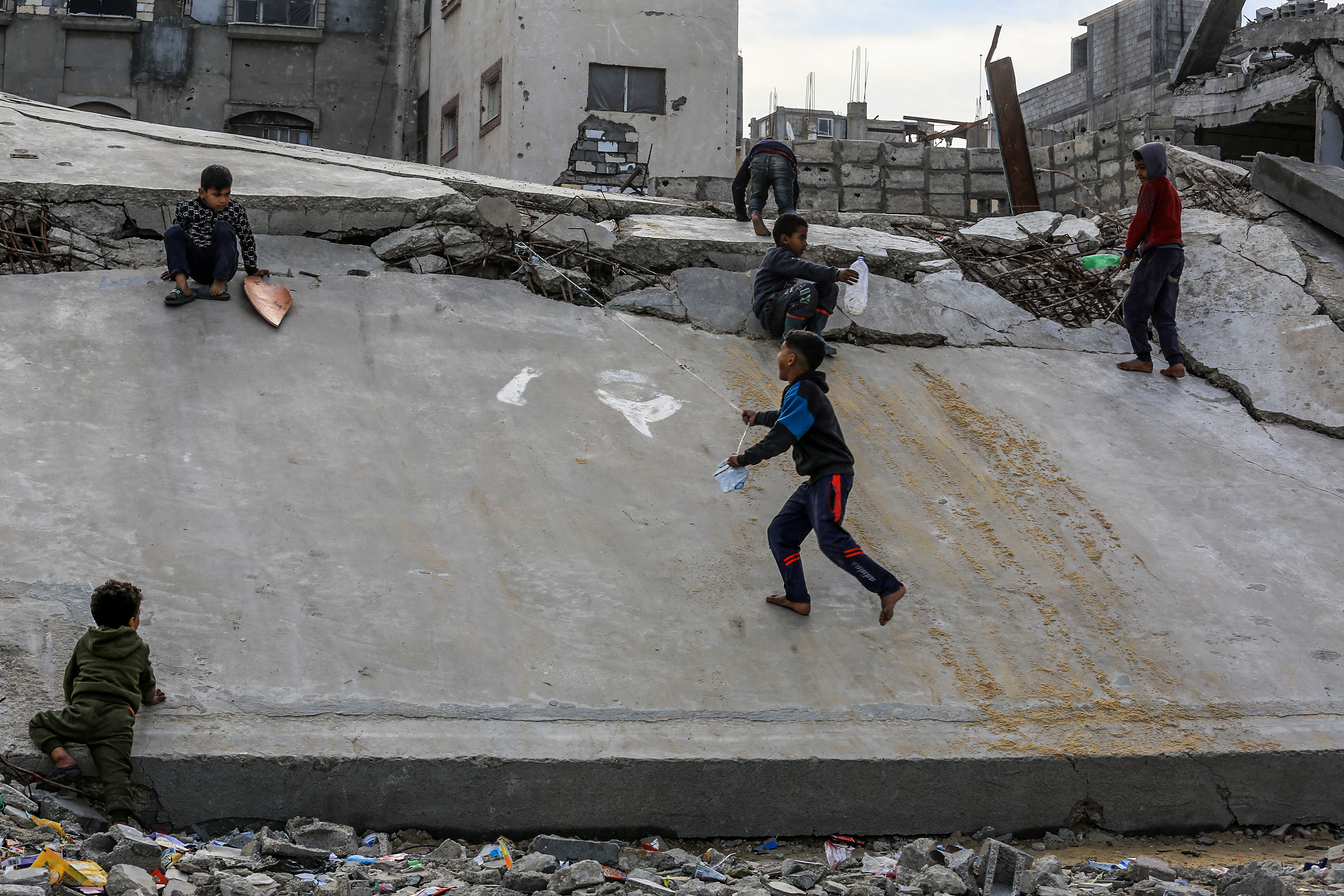 Palestinian children keep playing, even in the rubble of destroyed homes in Khan Yunis on February 14, 2025