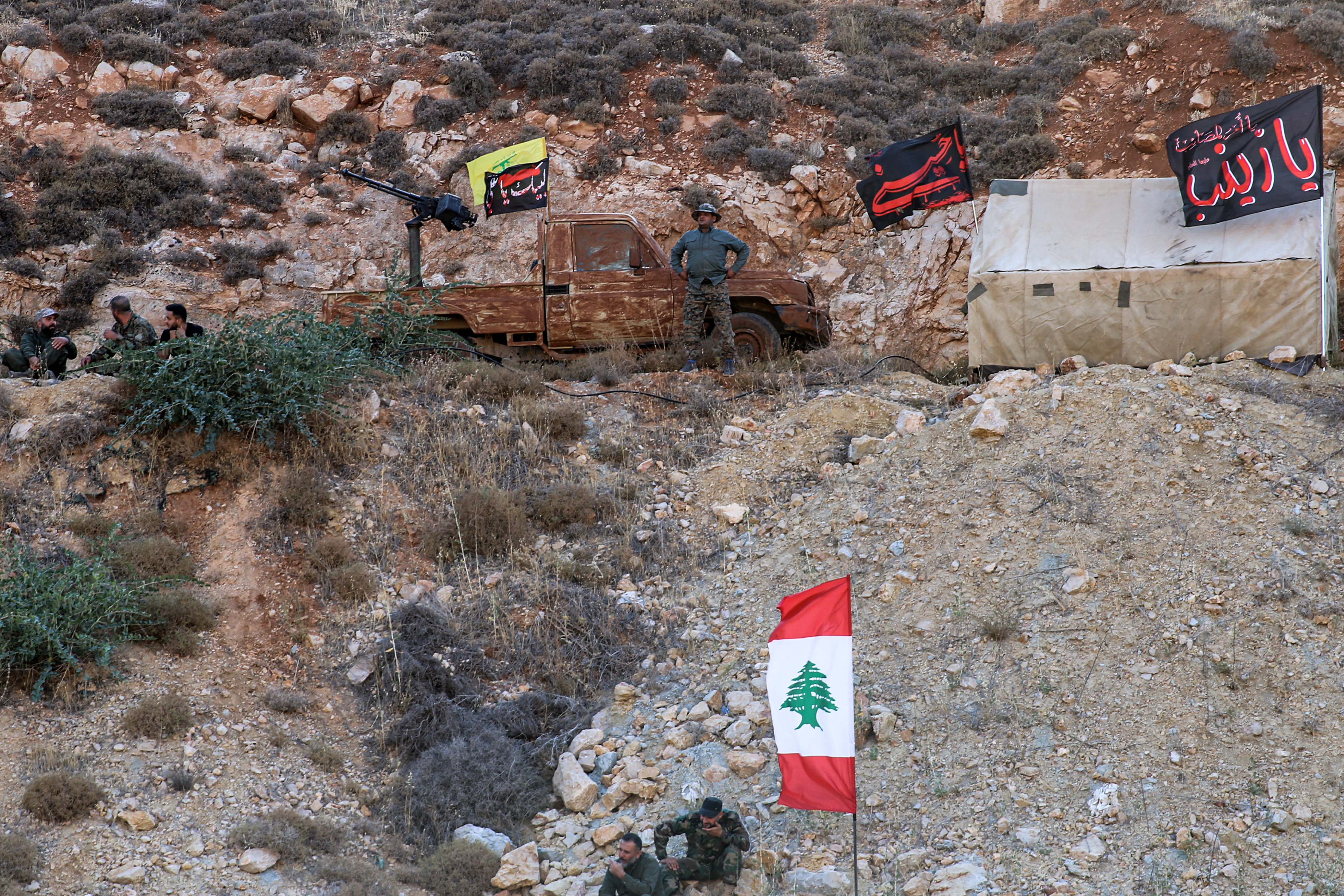 Hezbollah members pose with their group's flags in 2022 in Lebanon's Janta region [AFP]