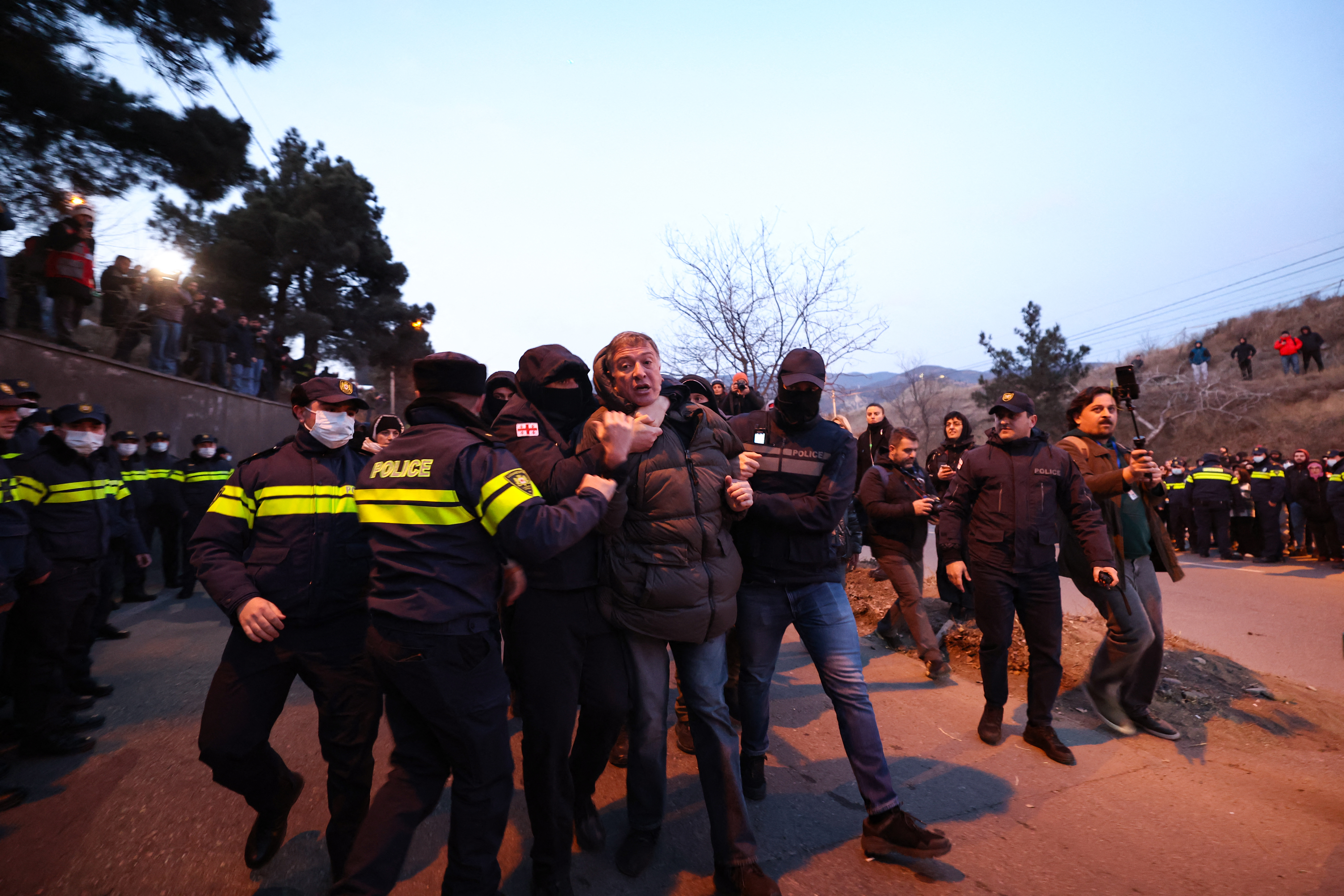 Georgian police detain a protester as anti-government demonstrators
