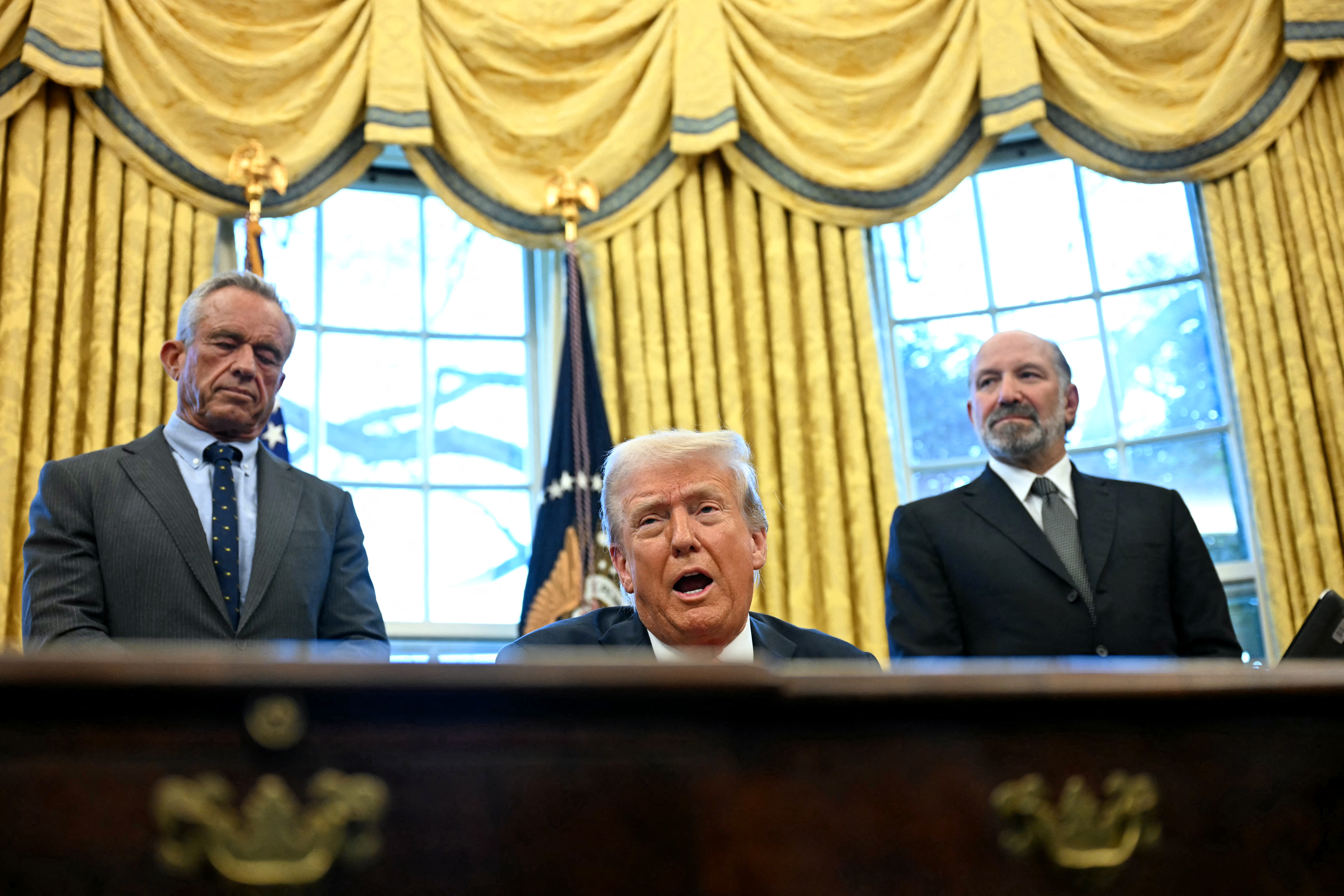 US President Donald Trump speaks to the press after signing an Executive Order, alongside US Secretary of Health and Human Services Robert F. Kennedy Jr. (L) and US Secretary of Commerce nominee Howard Lutnick (R), at the Oval Office of the White House in Washington, DC on February 25, 2025. Trump signed an executive order on price transparency requirements on the health care industry to reinstate and strengthen them. He also signed an order on the supply of copper and foreign copper in the American market, the order charges Lutnick with looking at process to potentially impose tariffs or trade barriers. (Photo by Jim WATSON / AFP)