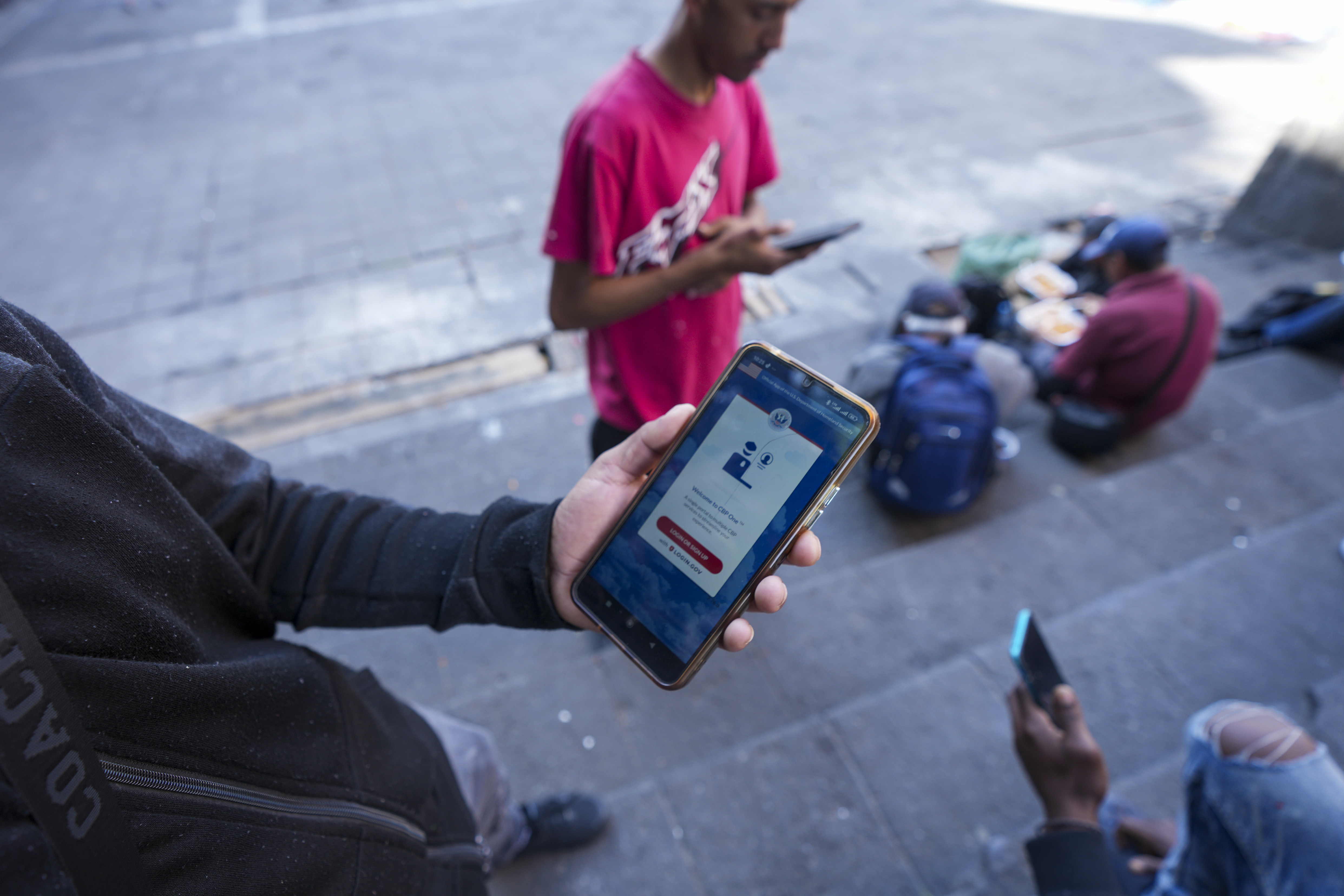 A person holds a phone with CBP One app