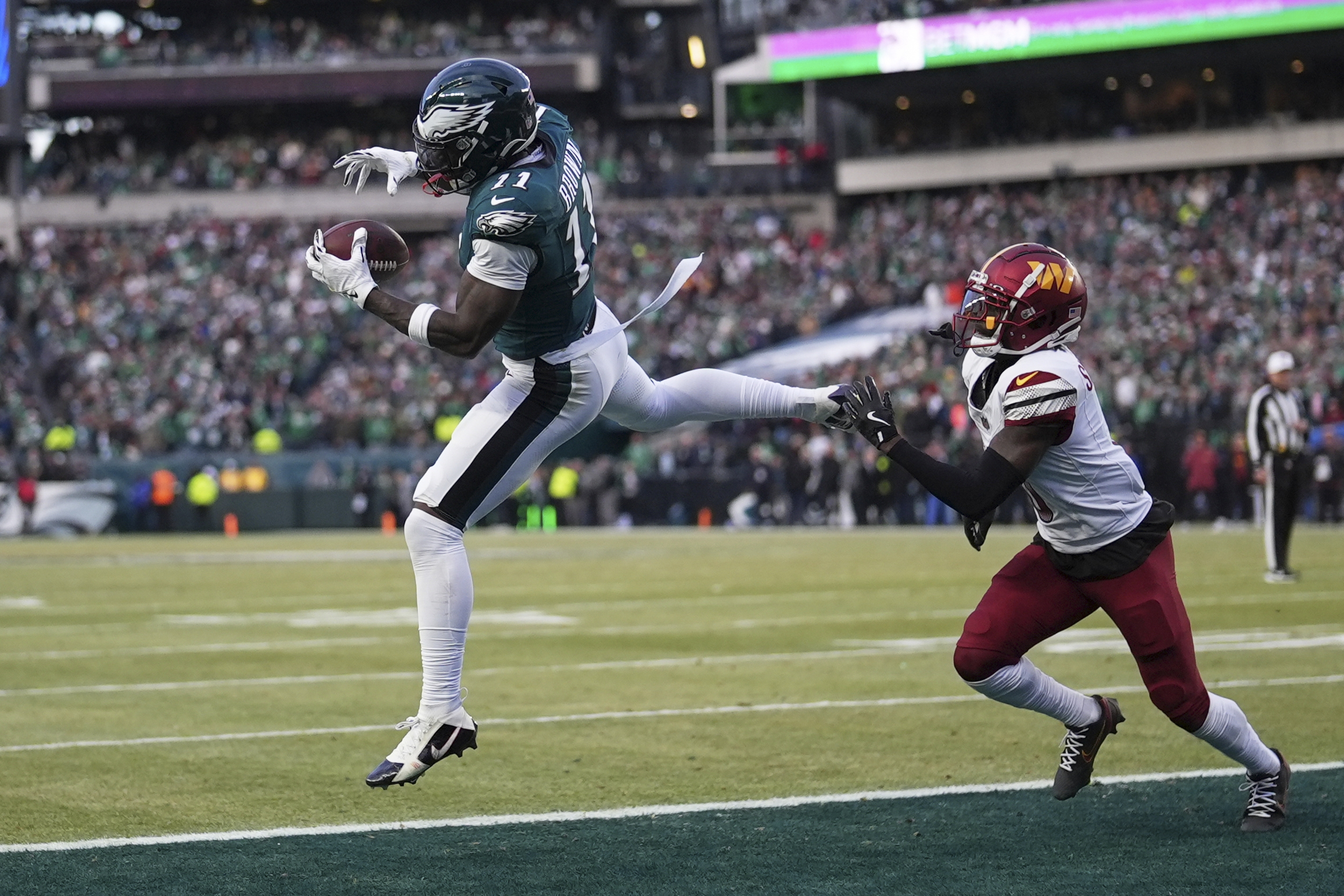 Philadelphia Eagles wide receiver AJ Brown, left, catches a pass for a touchdown as Washington Commanders cornerback Mike Sainristil defends during the NFC Championship Game in Philadelphia, Pennsylvania