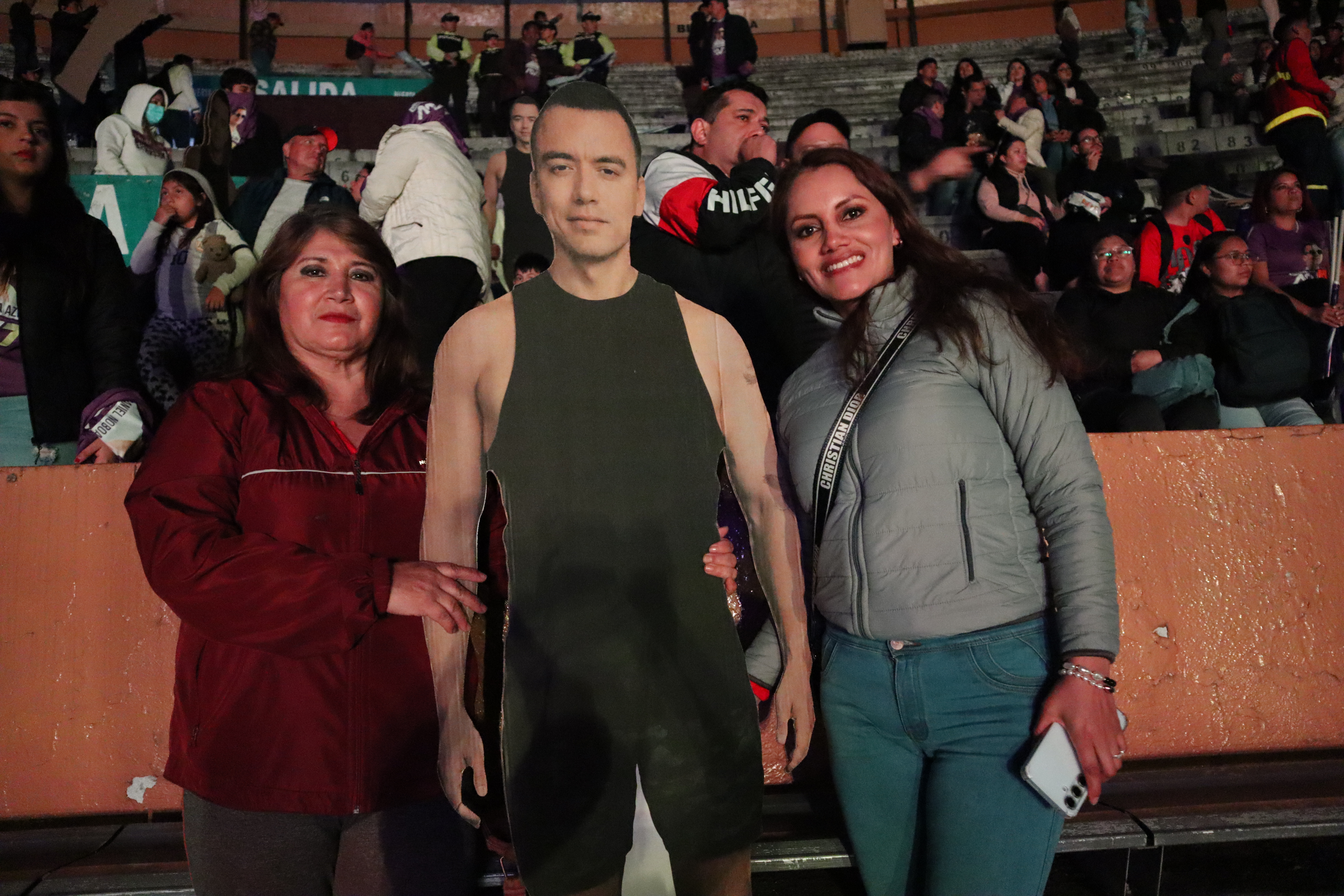 Two women stand on either side of a Noboa cardboard cut-out