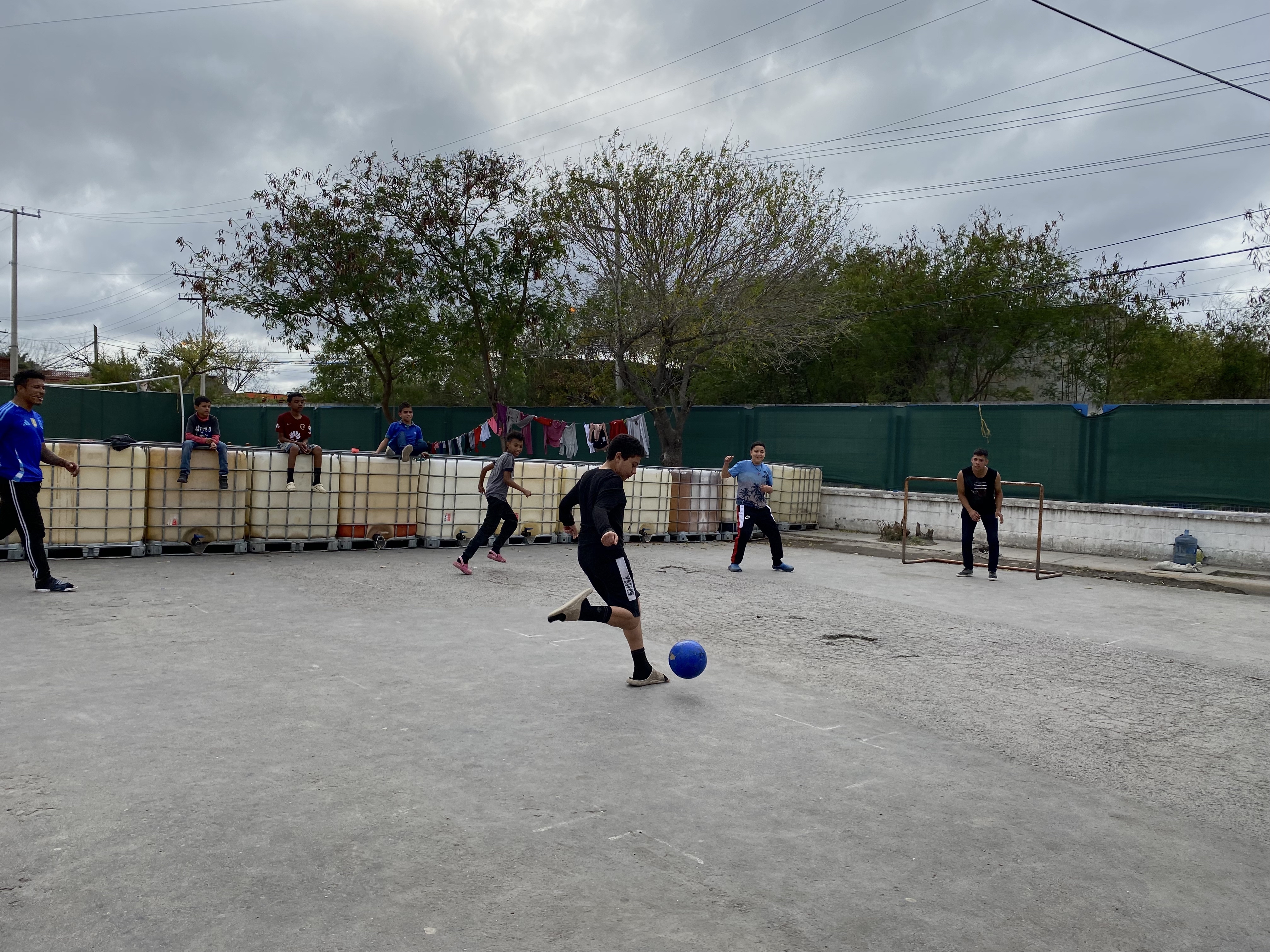Boys play football near a migrant shelter in Matamoros, Mexico