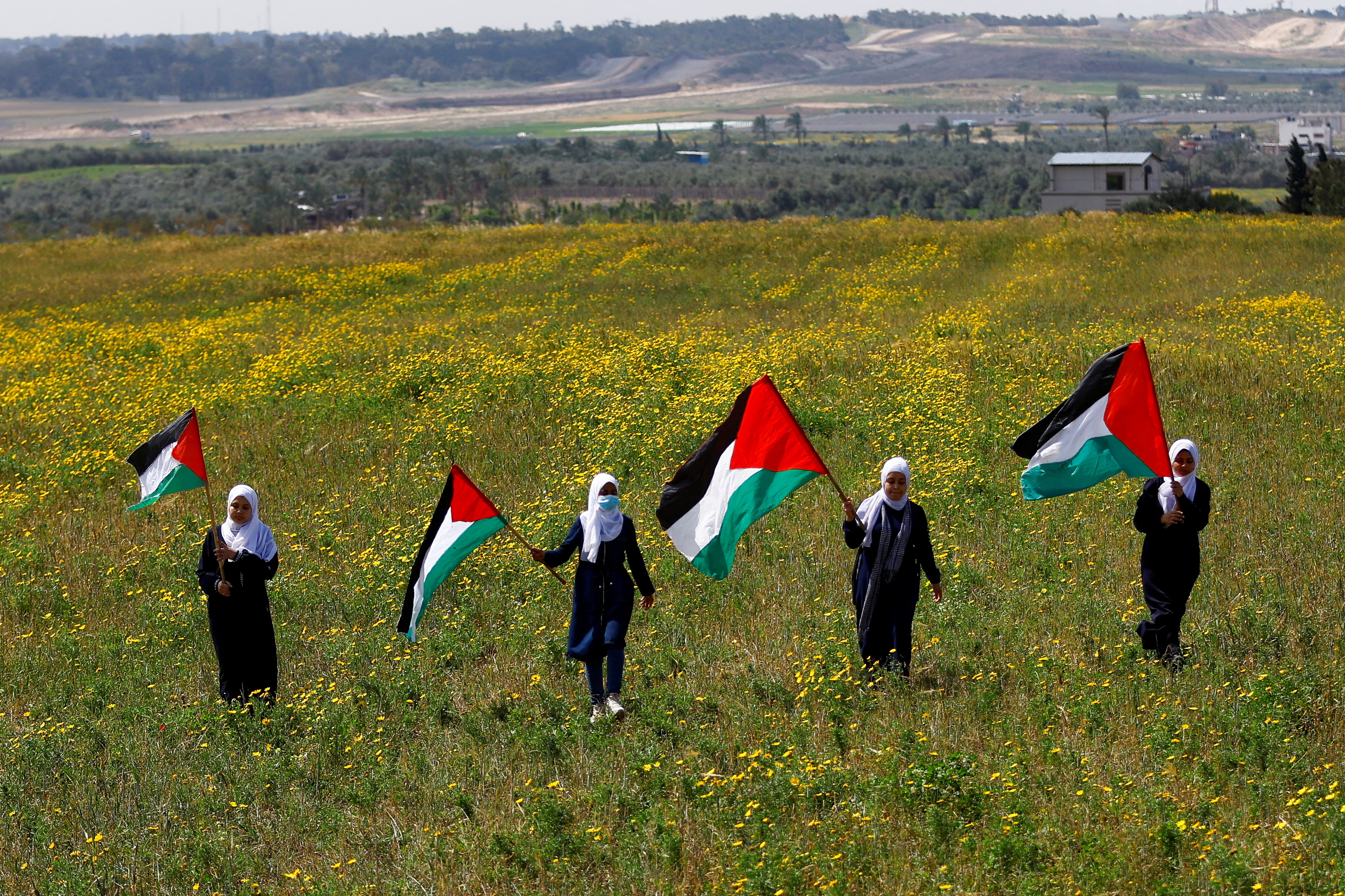 Palestinians hold flags as they mark Land Day, in the southeast of Gaza City on March 30, 2023