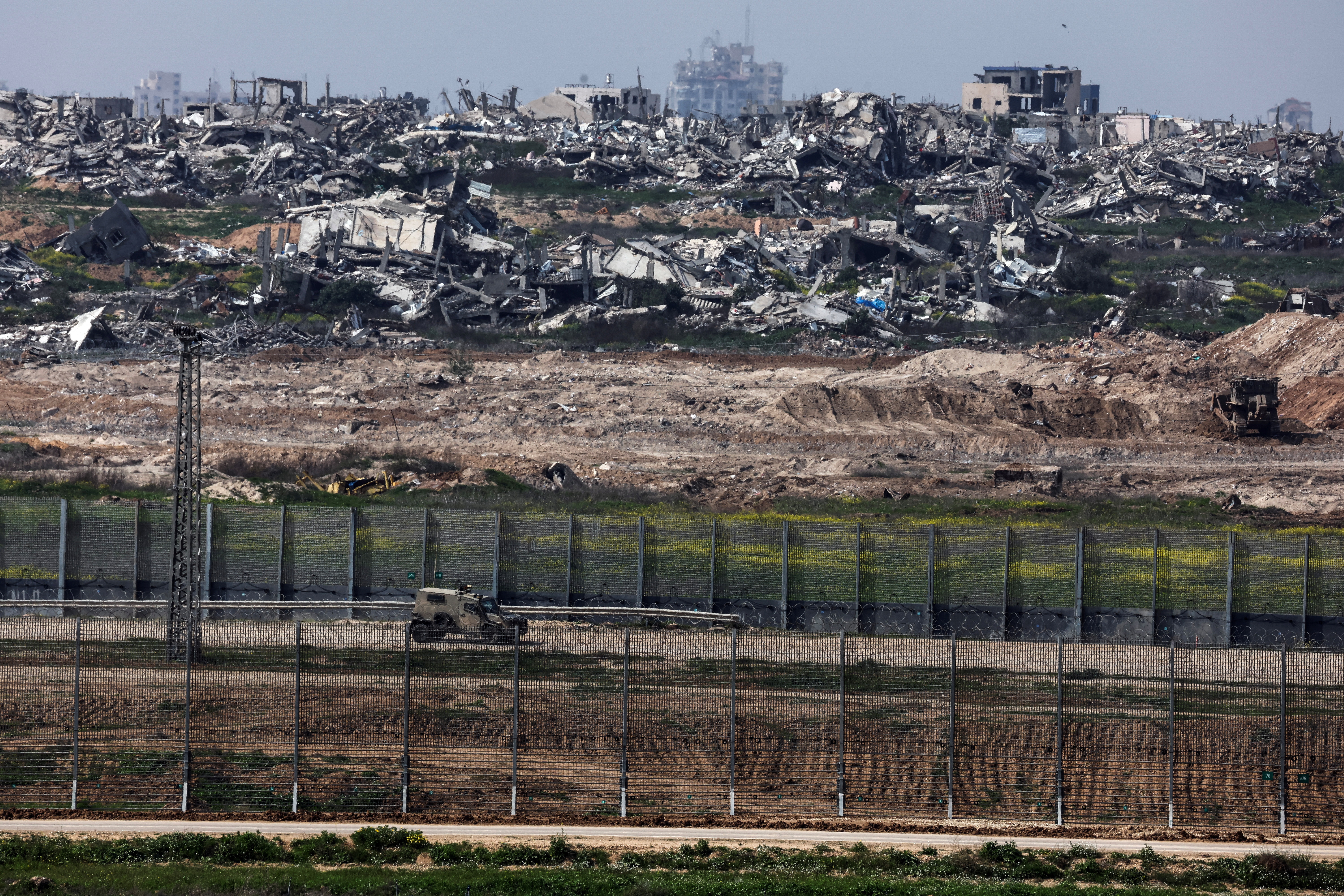 A military vehicle drives by the border between Israel and Gaza, as seen from southern Israel [Nir Elias/Reuters]