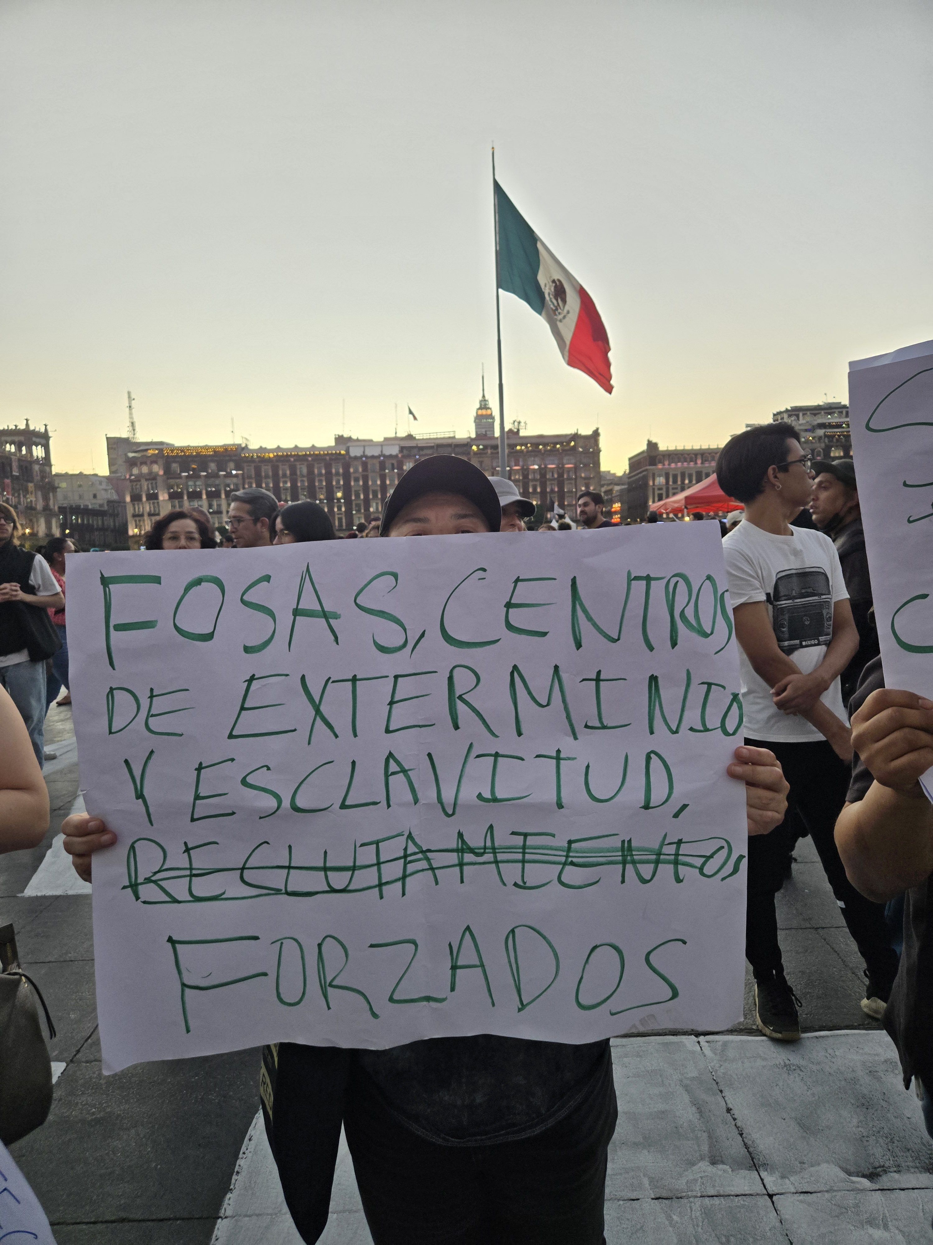 A woman holds up a sign that reads,
