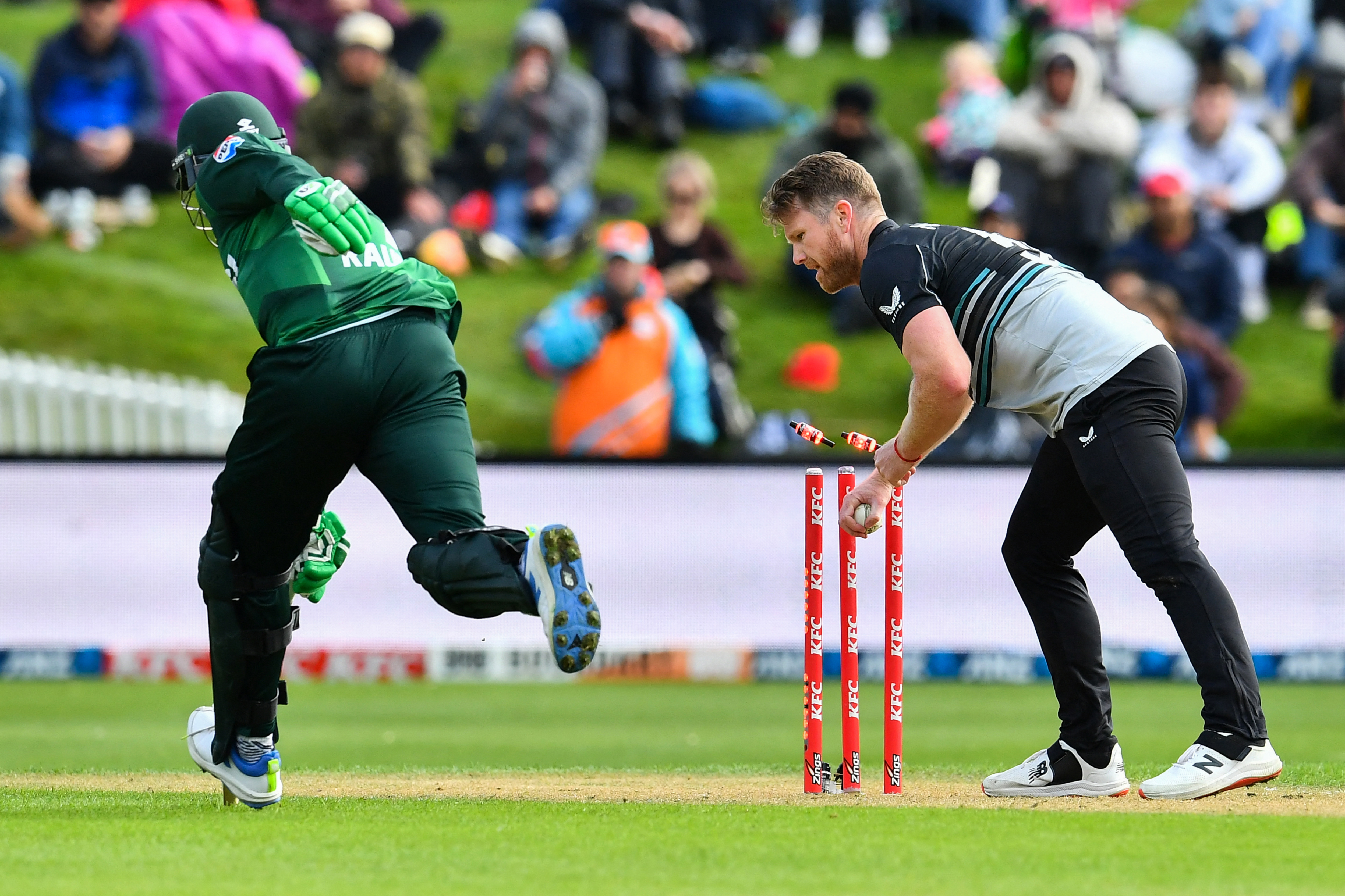 New Zealand's James Neesham (R) removes bails to runout Pakistan's Haris Rauf during the second Twenty20 international cricket match between New Zealand and Pakistan at University of Otago Oval in Dunedin on March 18, 2025. (Photo by Sanka Vidanagama / AFP)