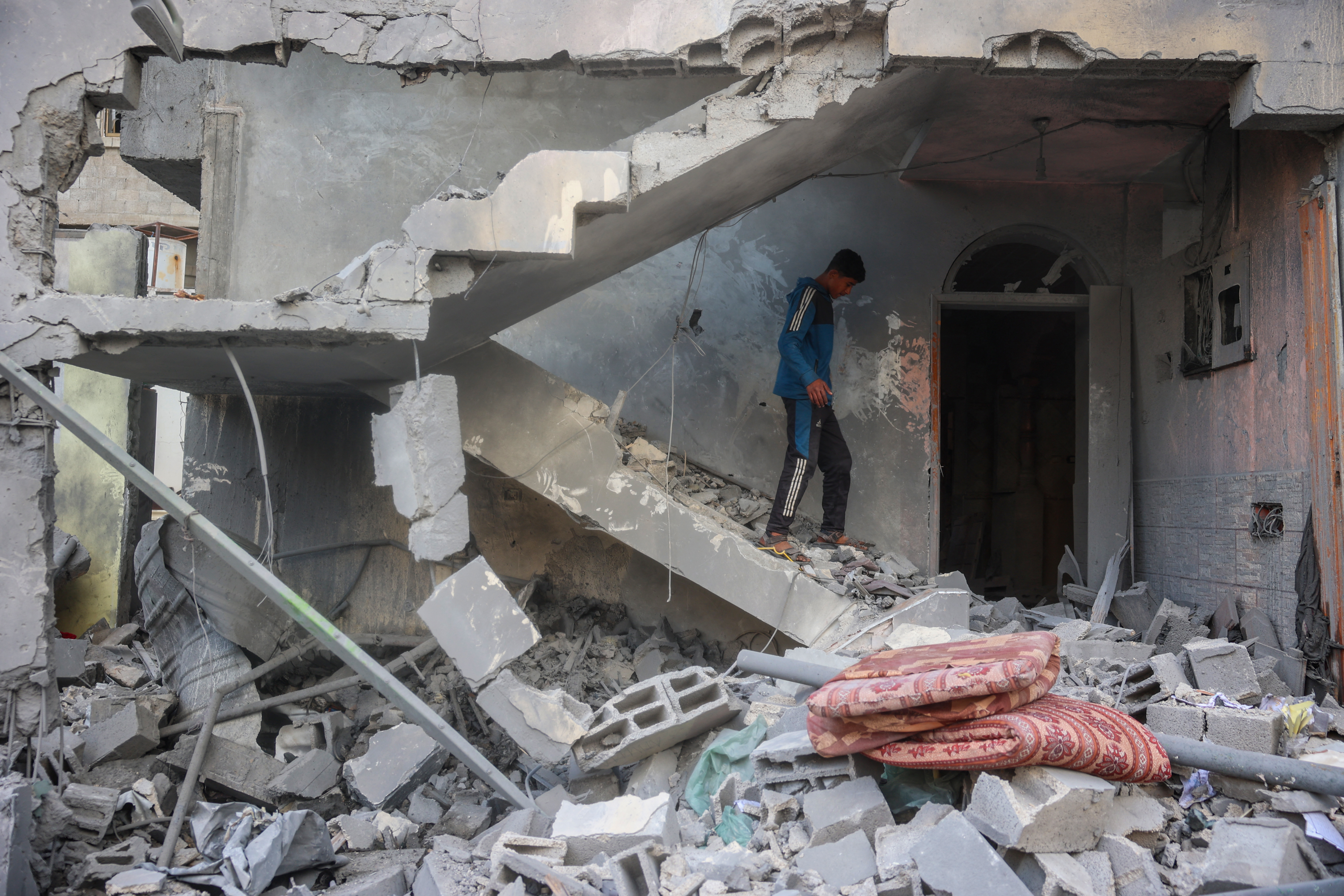 A boy walks on the rubble of his home, destroyed in an Israeli strike, in the Nuseirat refugee camp in the central Gaza Strip on March 18, 2025. Israel on March 18 unleashed its most intense strikes on the Gaza Strip since a January ceasefire, with rescuers reporting 220 people killed, and Hamas accusing Benjamin Netanyahu of deciding to "resume war" after a deadlock on extending the truce. (Photo by Eyad BABA / AFP)