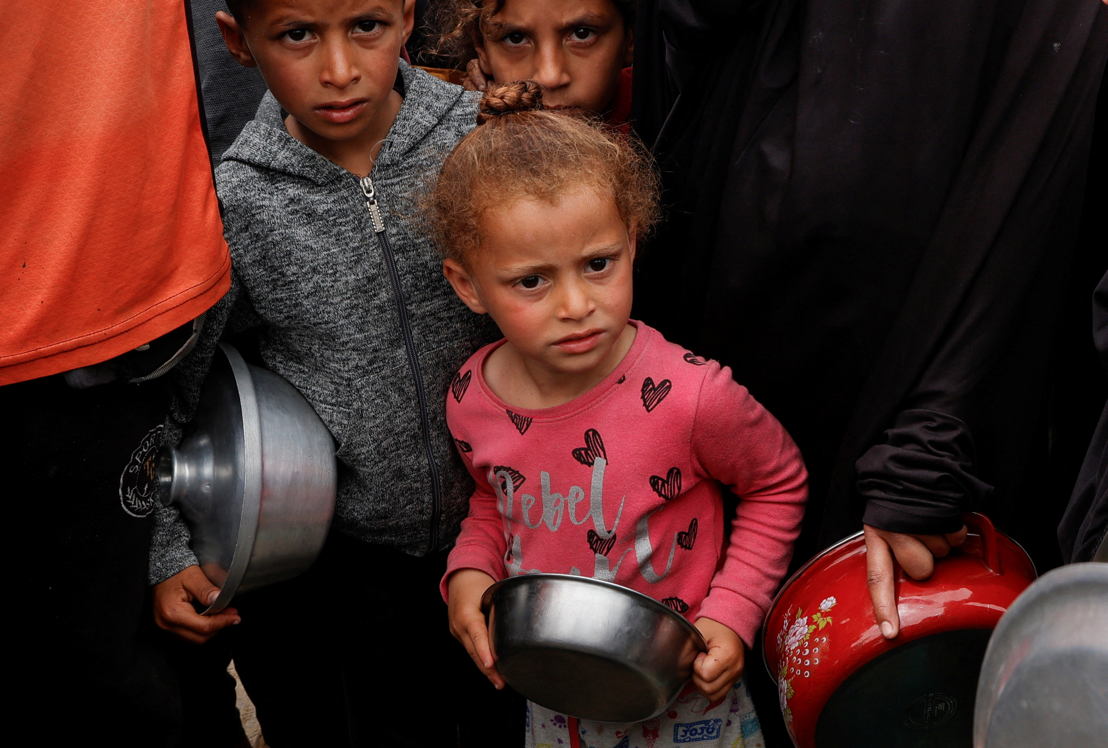 Palestinians gather to receive food cooked by a charity kitchen.