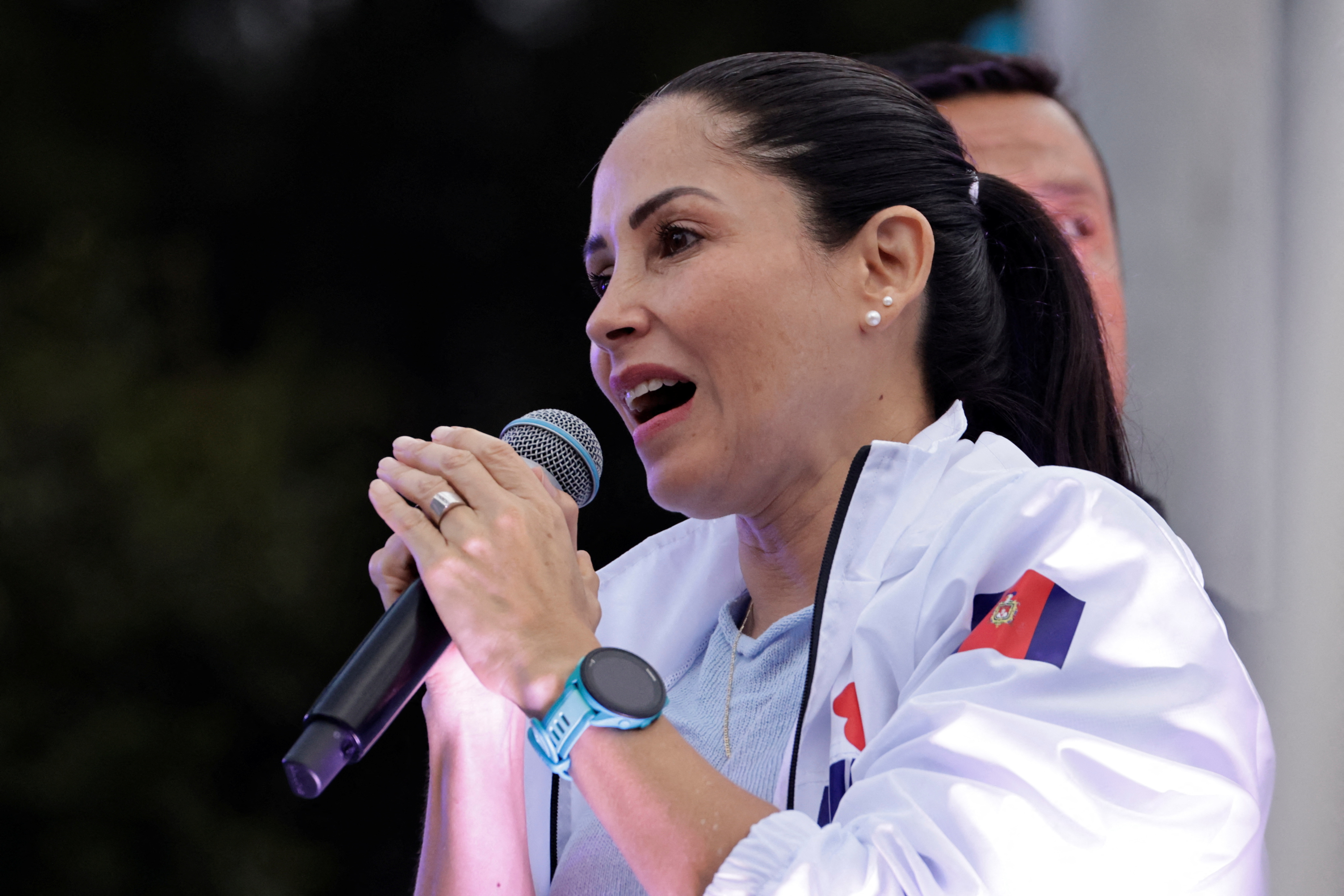 Luisa Gonzalez speaks into a handheld microphone