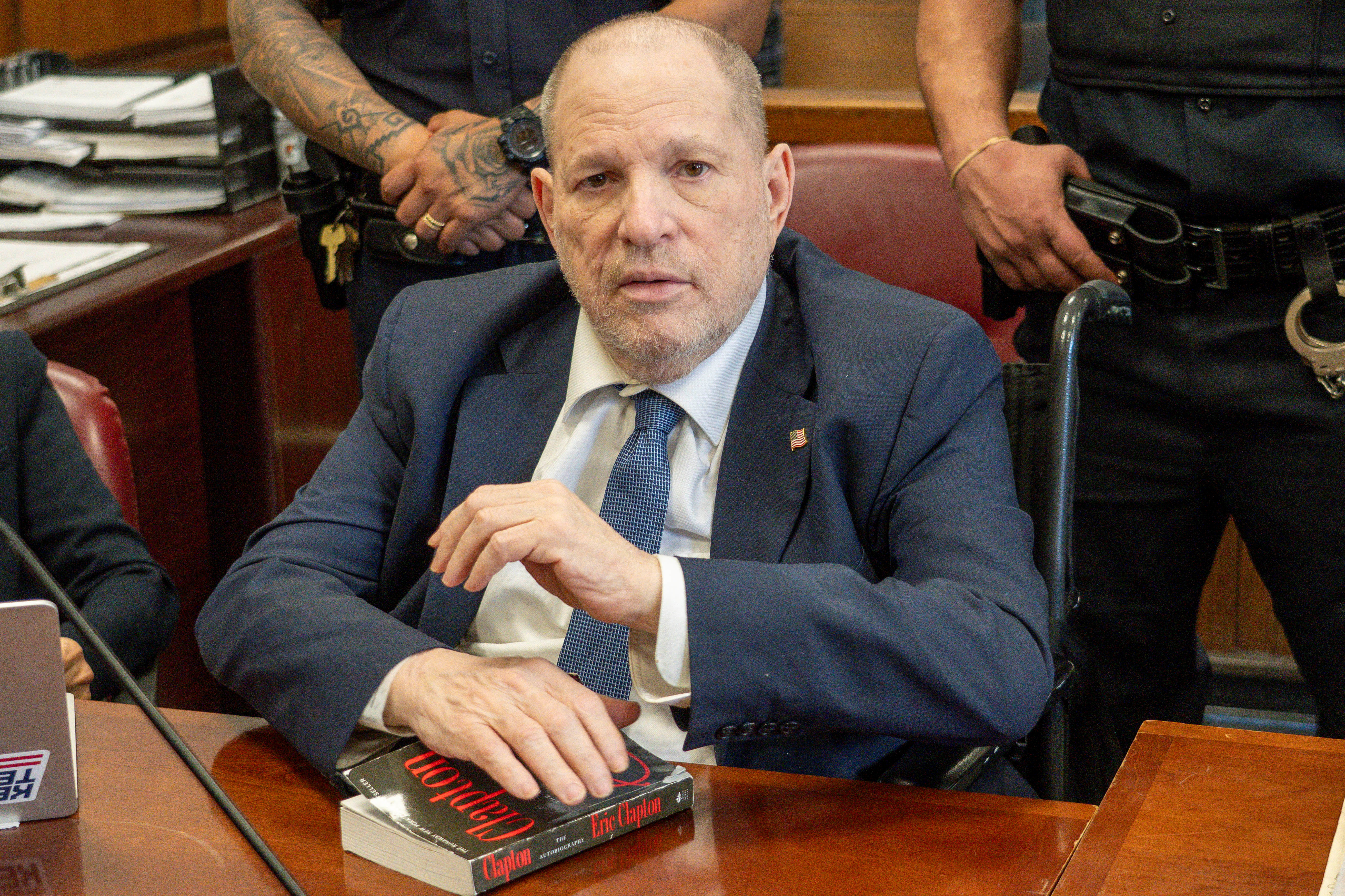 Disgraced Hollywood film producer Harvey Weinstein holds an Eric Clapton autobiography in Manhattan Criminal Court