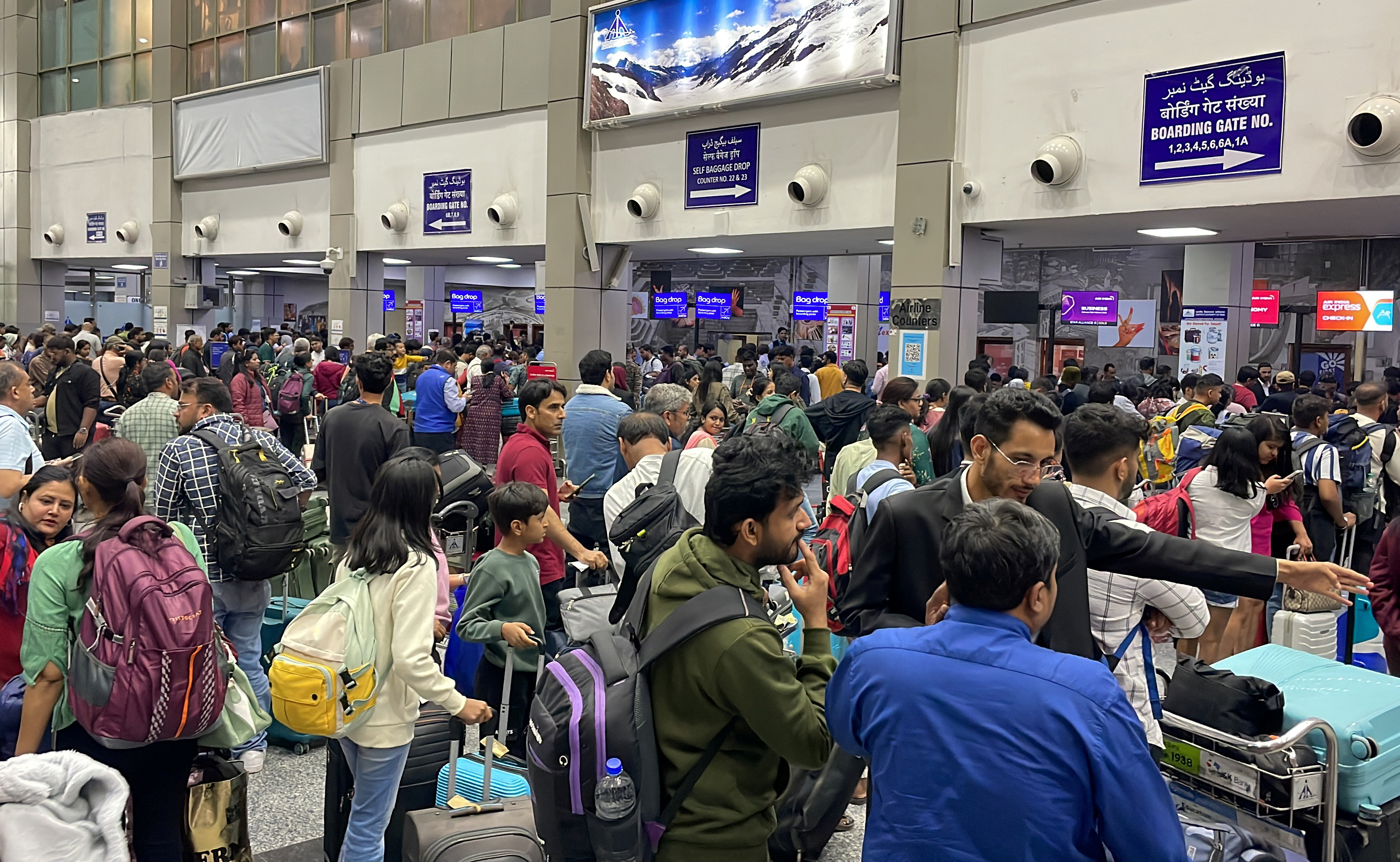 Tourists wait near check-in desks at the airport in Budgam district, as they try to leave following an attack in Baisaran near south Kashmir’s Pahalgam, on April 24, 2025