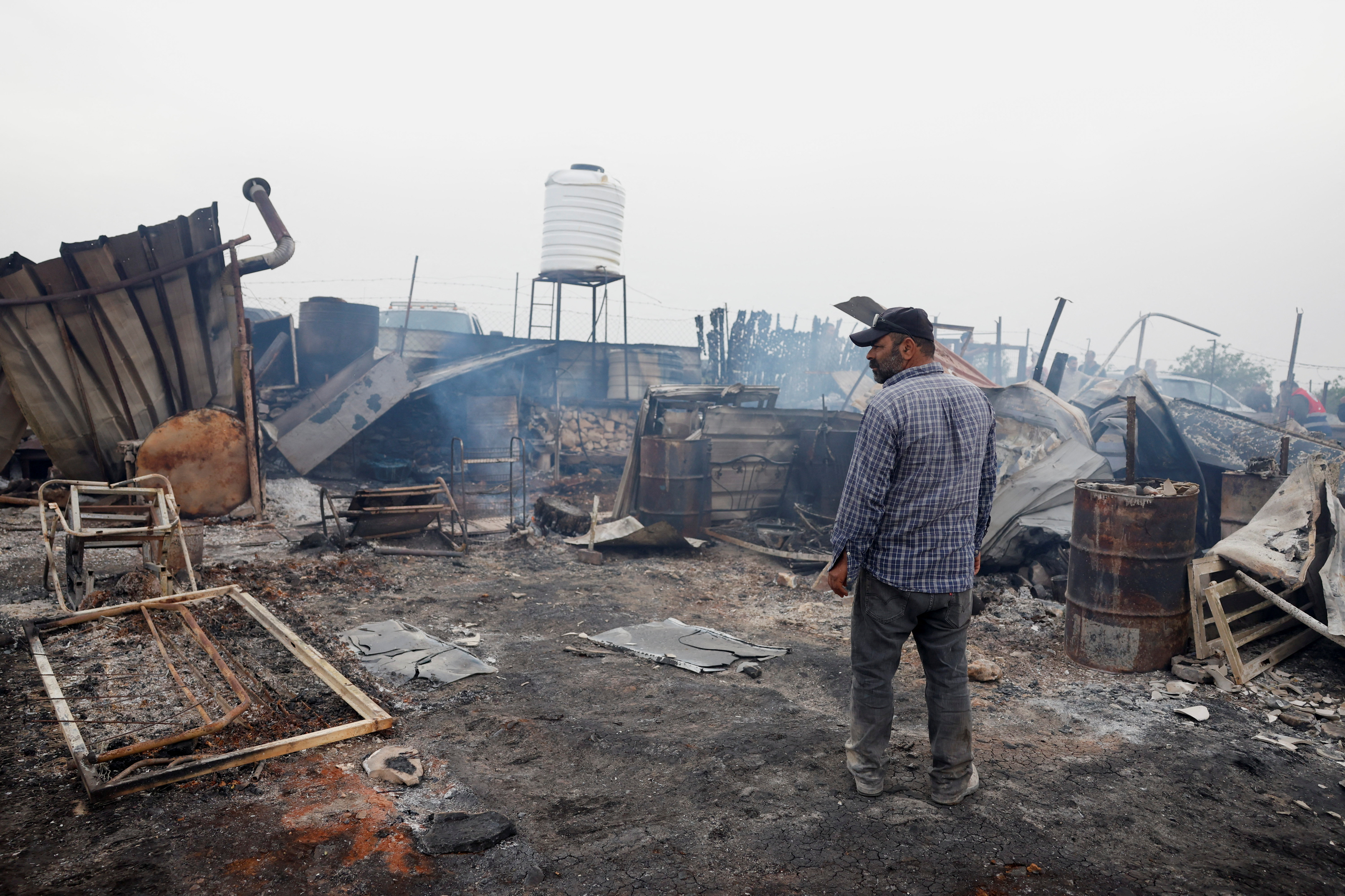 A Palestinian inspects the damage after an attack by Israeli settlers, in Sinjil, near Ramallah, in the Israeli-occupied West Bank April 23, 2025. REUTERS/Mohammed Torokman