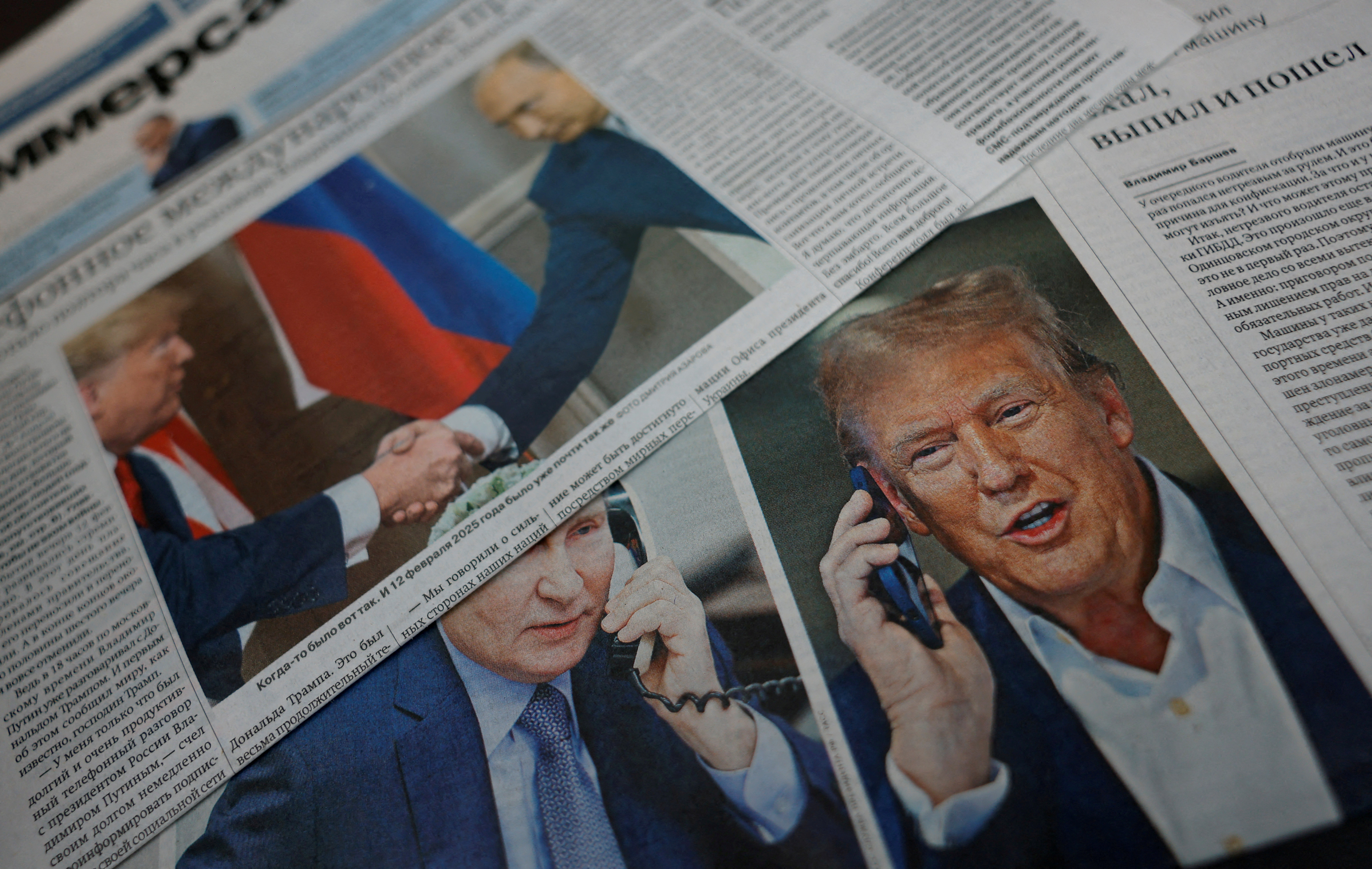 Daily newspapers with covers, dedicated to the recent phone call of Russian President Vladimir Putin and US President Donald Trump, are laid out at a newsstand.
