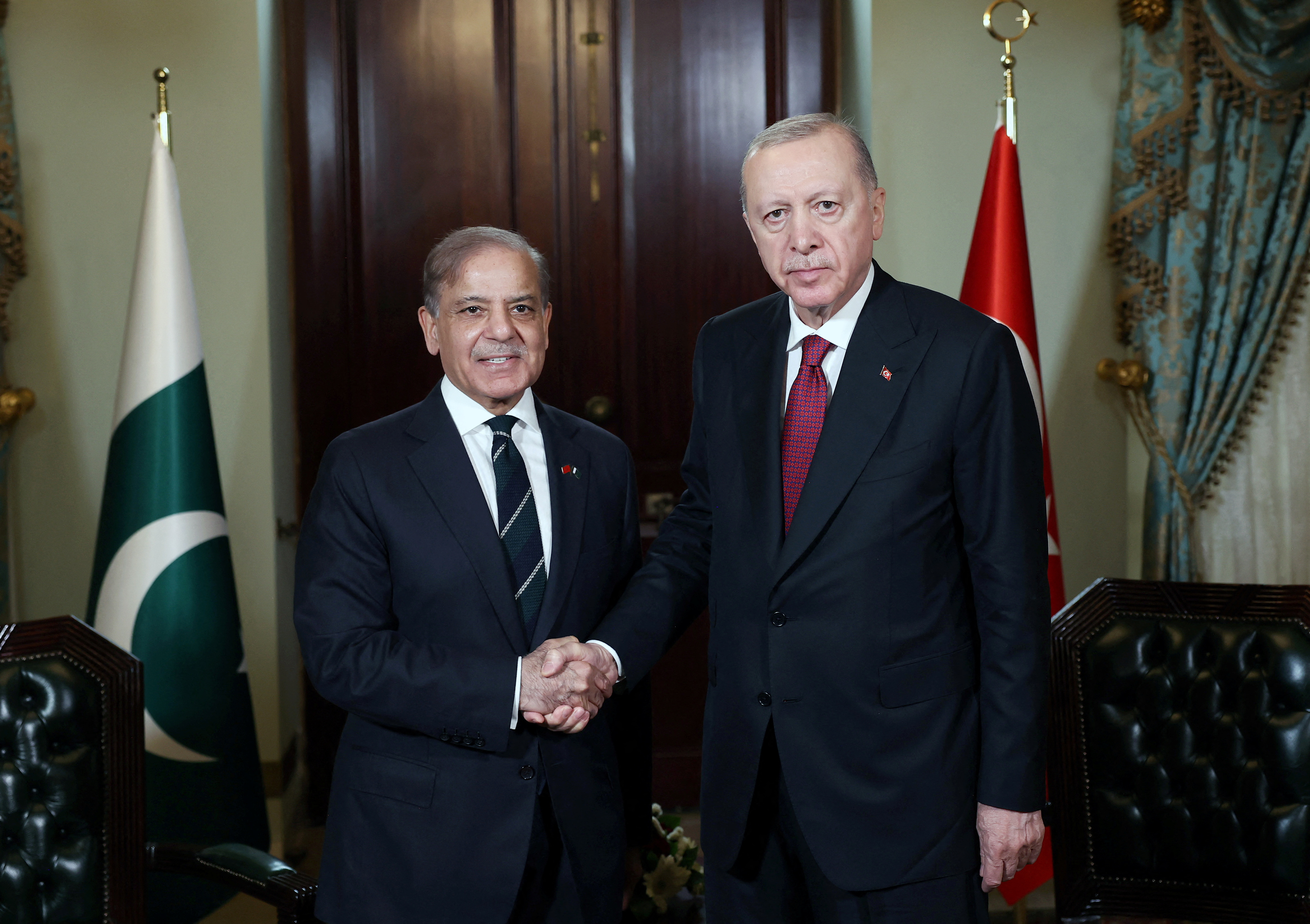 Turkey’s President Tayyip Erdogan shakes hands with Pakistan's Prime Minister Shehbaz Sharif .
